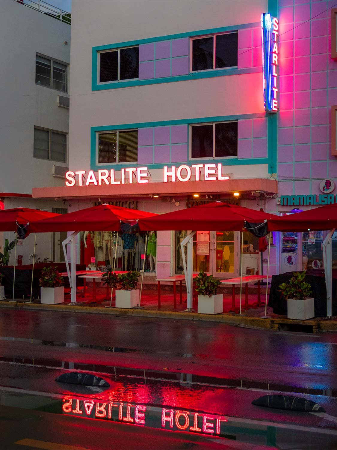 Starlite Hotel neon sign Miami Beach Ocean Drive South Beach boutique hotel outdoor seating rainy night.