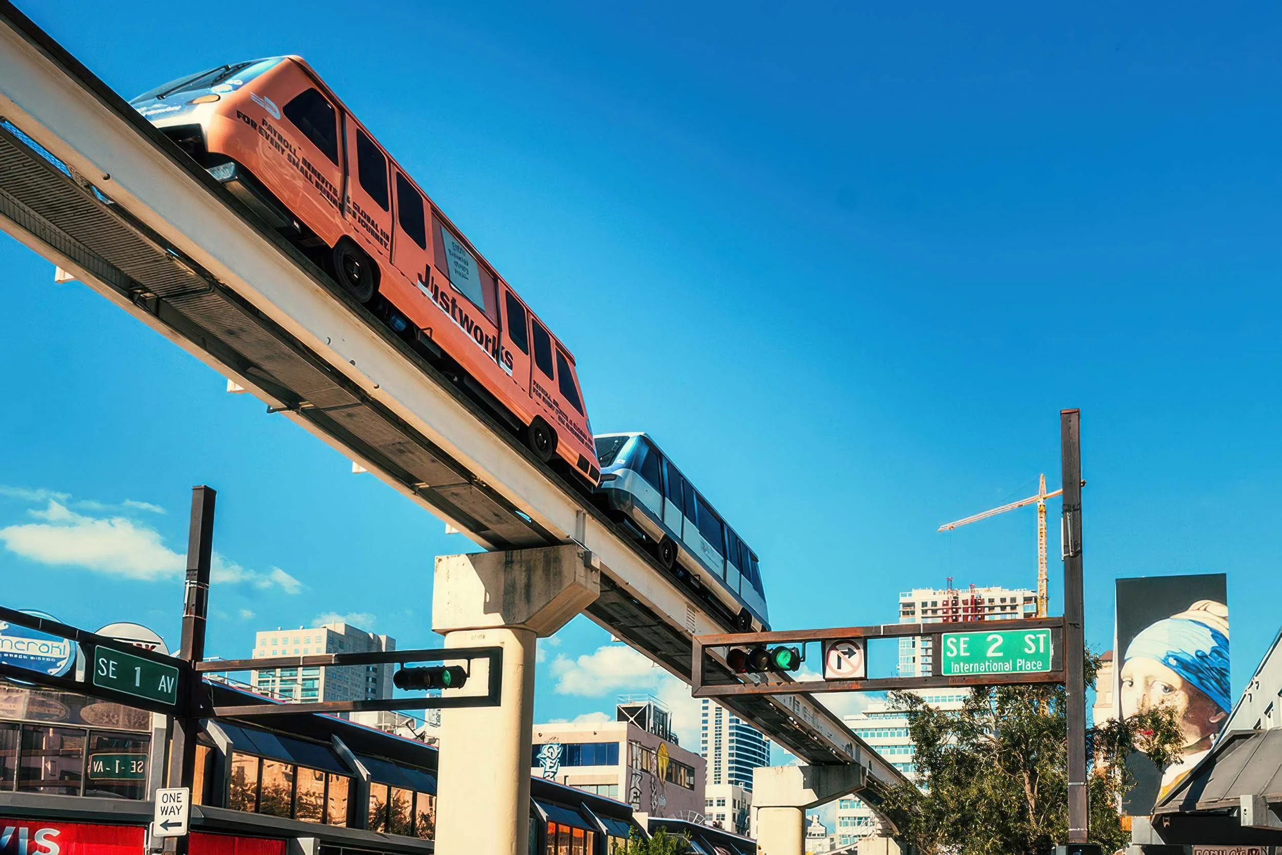 Metromover cars on the elevated track above SE 2nd Street and SE 1st Avenue in Downtown Miami