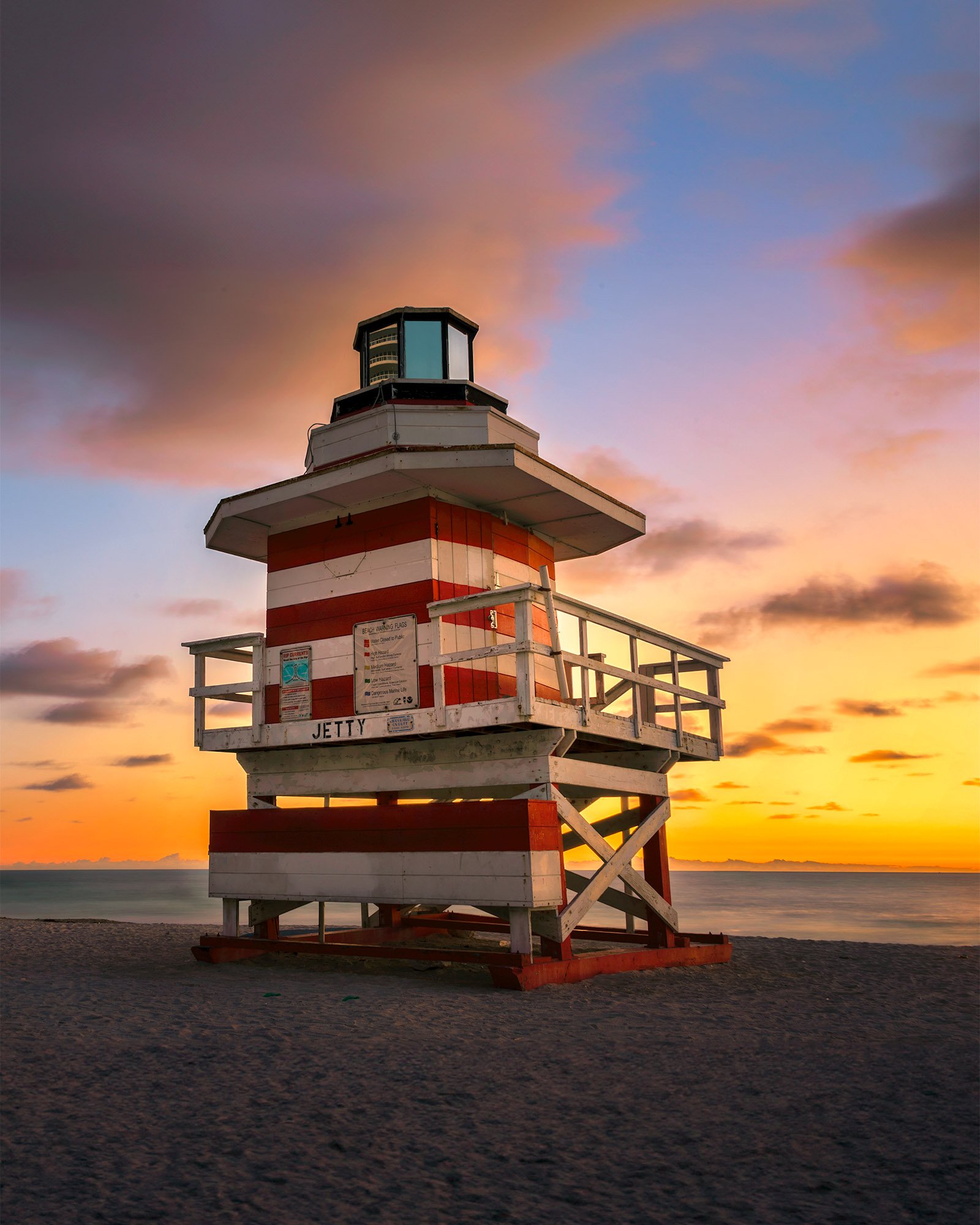Original Jetty lifeguard tower at South Pointe Park at sunrise, red and white stripes with JETTY lettered on the deck, Miami Beach