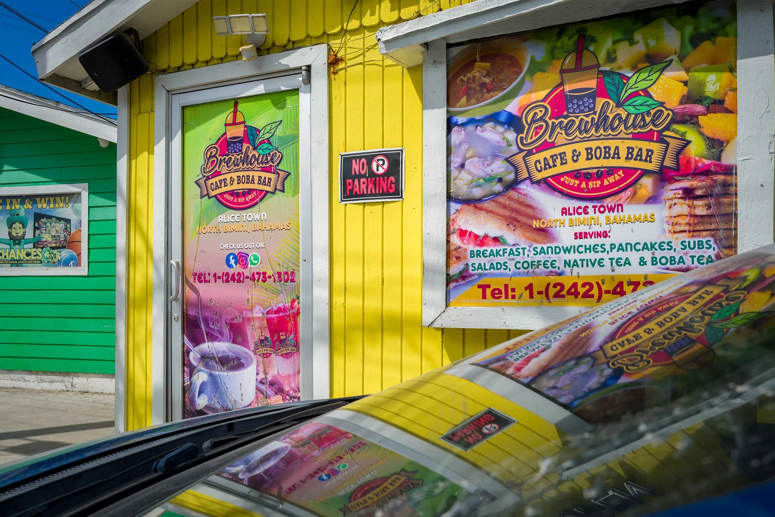 Street photography by Kameron Brothers - a colorful wooden building reflecting off the car window