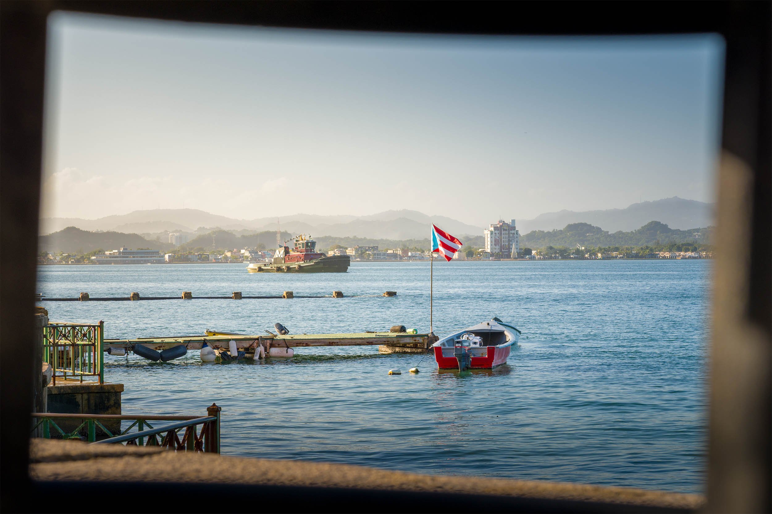 Puerto Rican flags blows in the wind in the water off Old San Juan