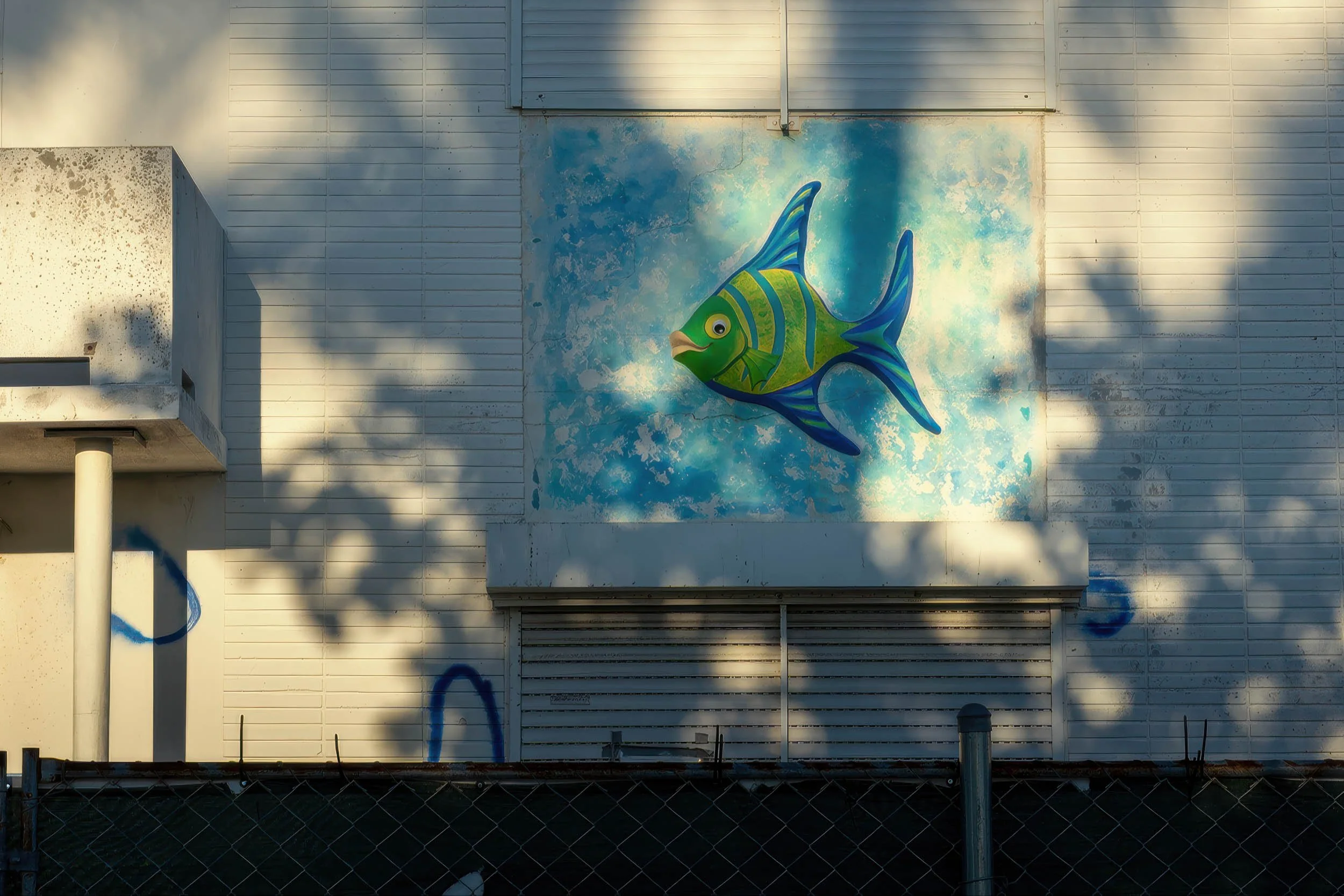 Detail of a hand-painted fish mural on a shuttered hotel facade, Ocean Terrace North Beach