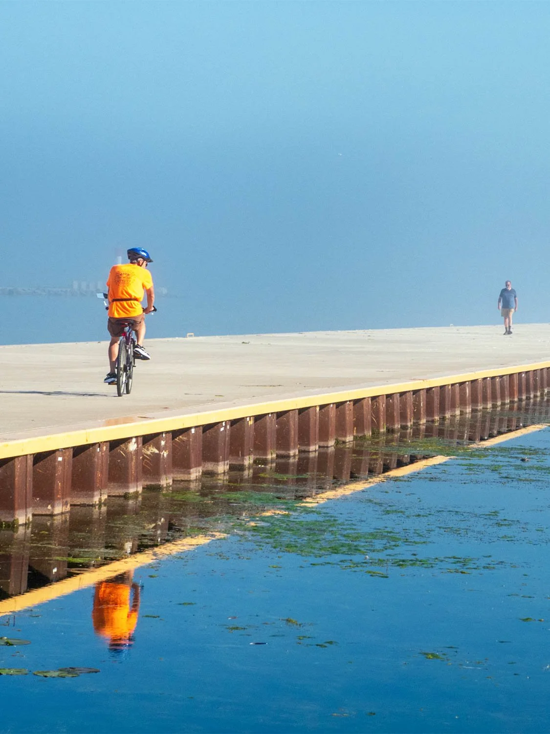 waterfront bike path cycling pier outdoor recreation coastal trail blue water reflection sunny day