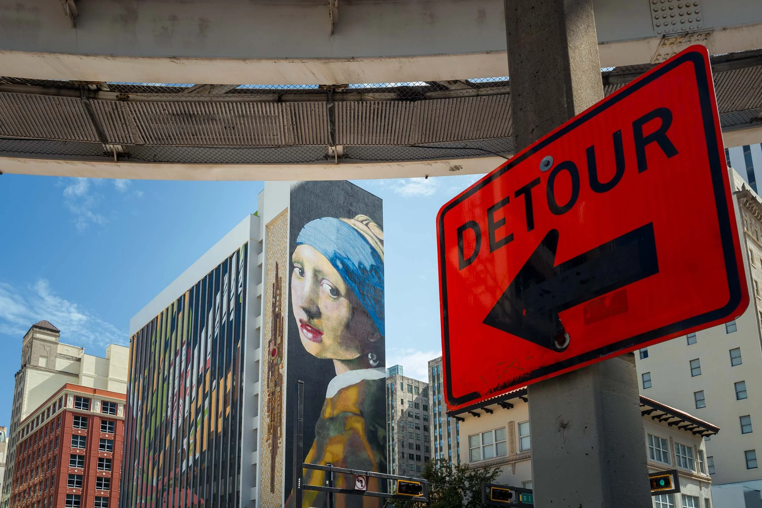 Large Girl with a Pearl Earring mural on a Downtown Miami building with a red detour sign in the foreground