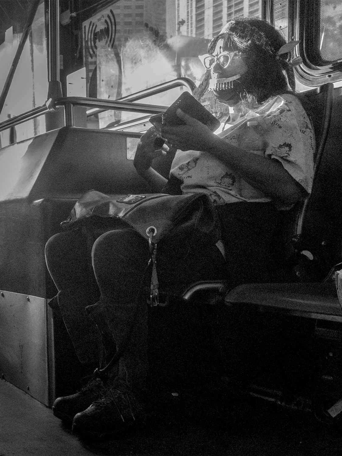 Street photography skull mask urban bus rider alternative fashion black and white editorial portrait.