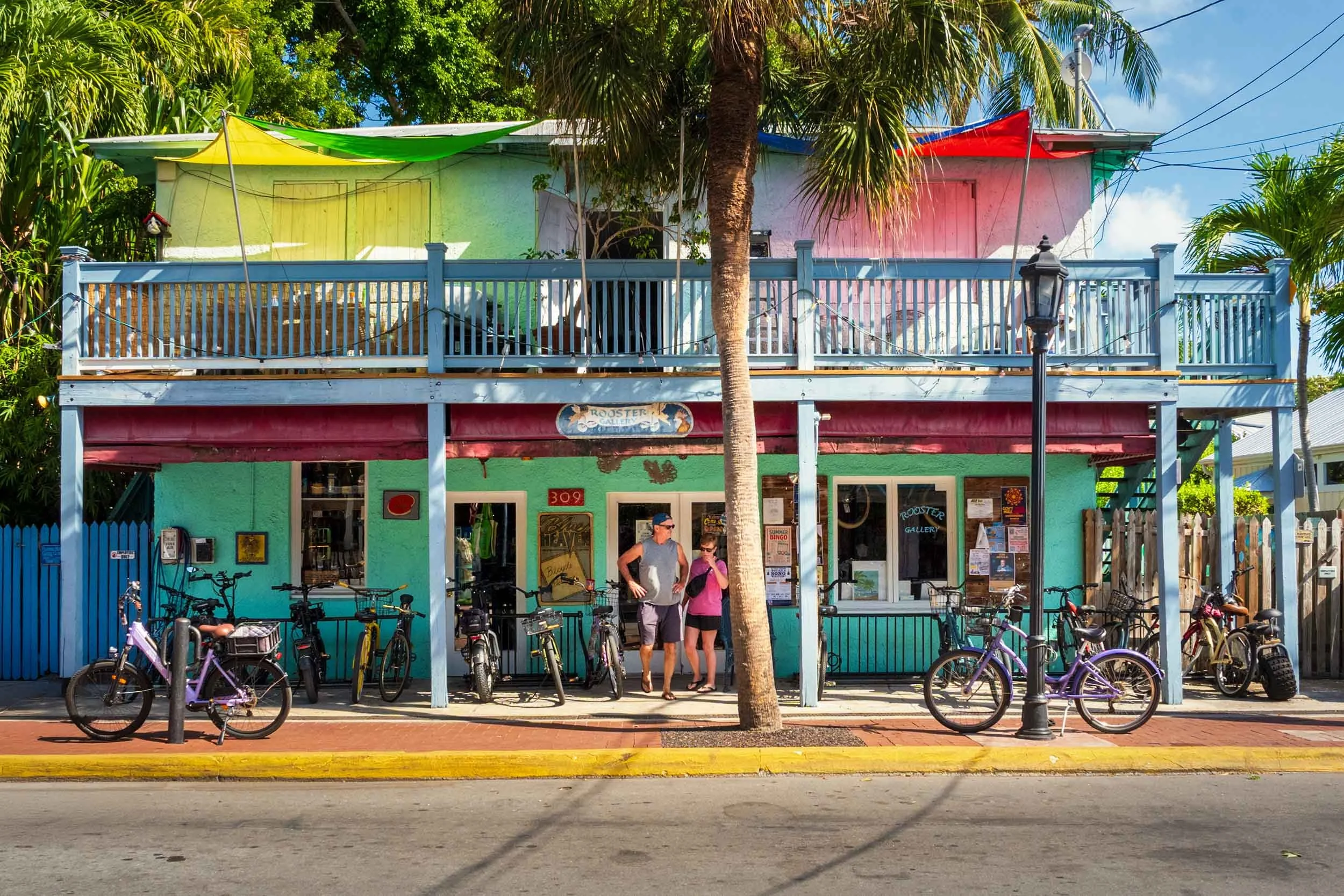 Key West Rooster Gallery shop 309 Duval Street teal building bikes palm tree tourists Florida Keys