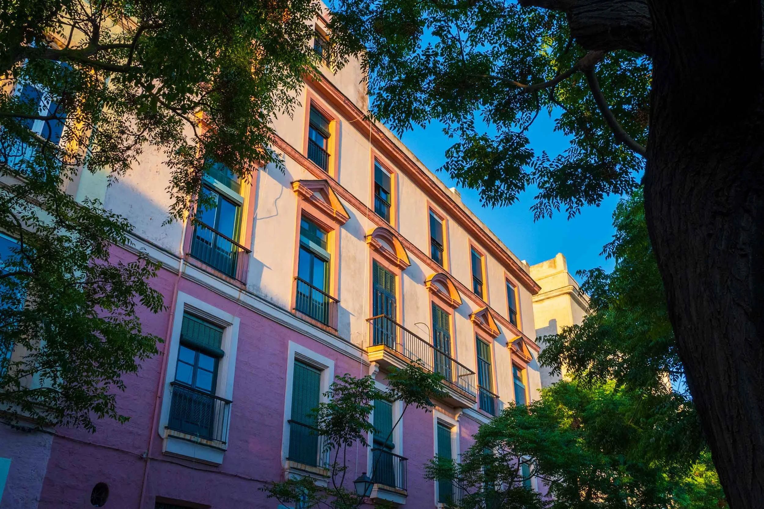 Cadiz Spain historic architecture pink facade balconies old town building sunset golden hour travel