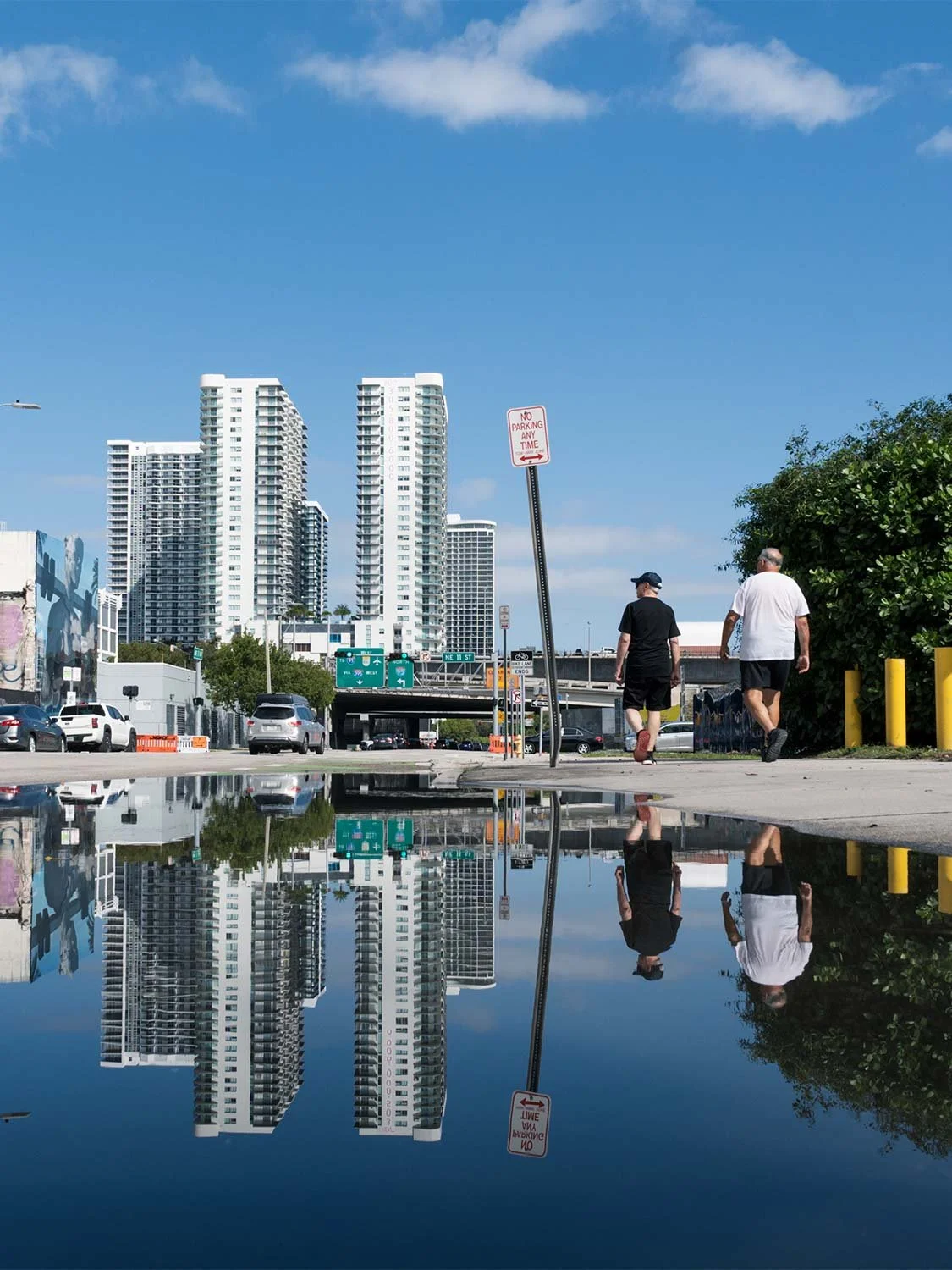 Midtown Miami urban street reflection puddle luxury condos skyline pedestrians city living Florida real estate