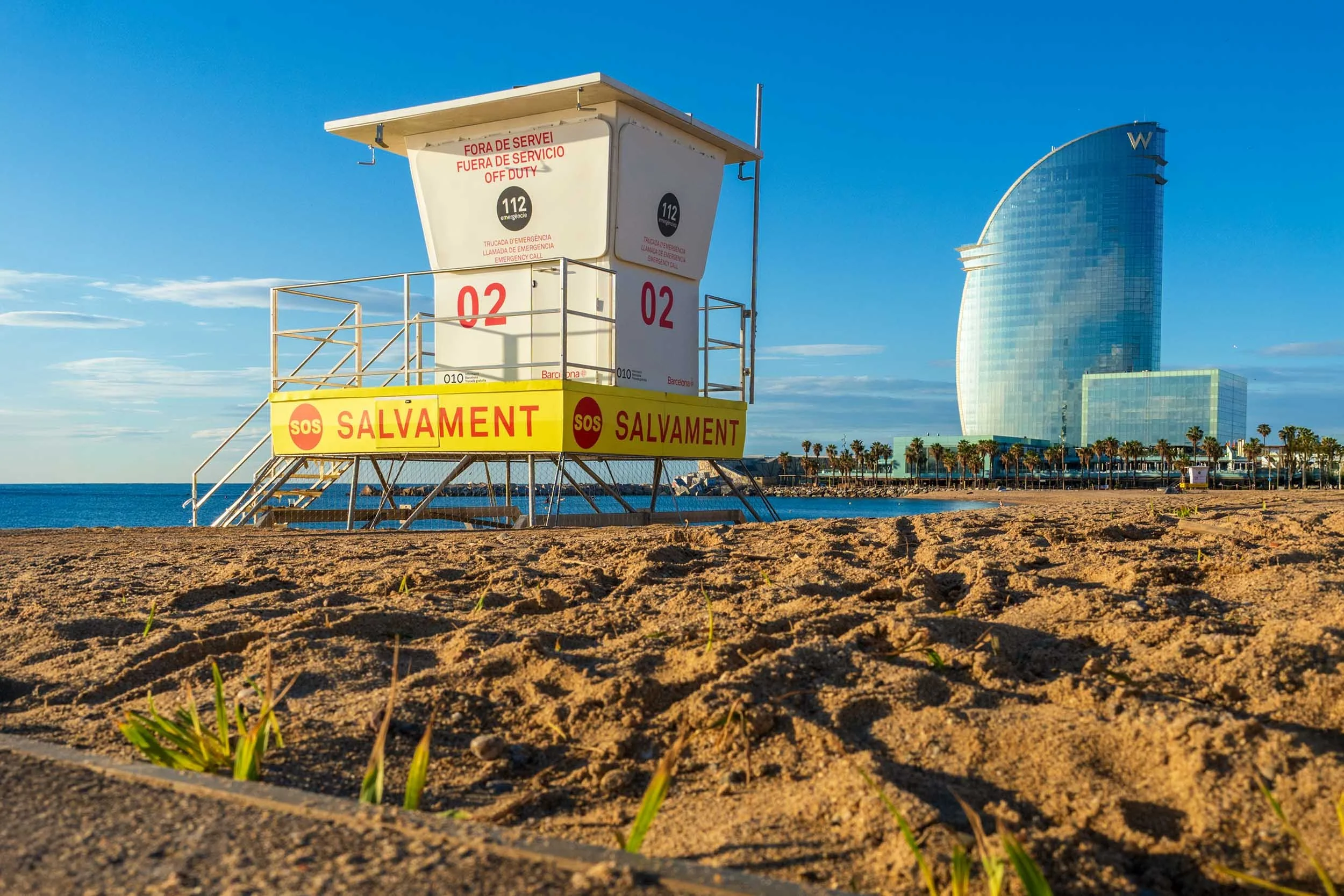 Salvament lifeguard tower number 02 on Barceloneta beach, the sail-shaped W Barcelona hotel rising behind it