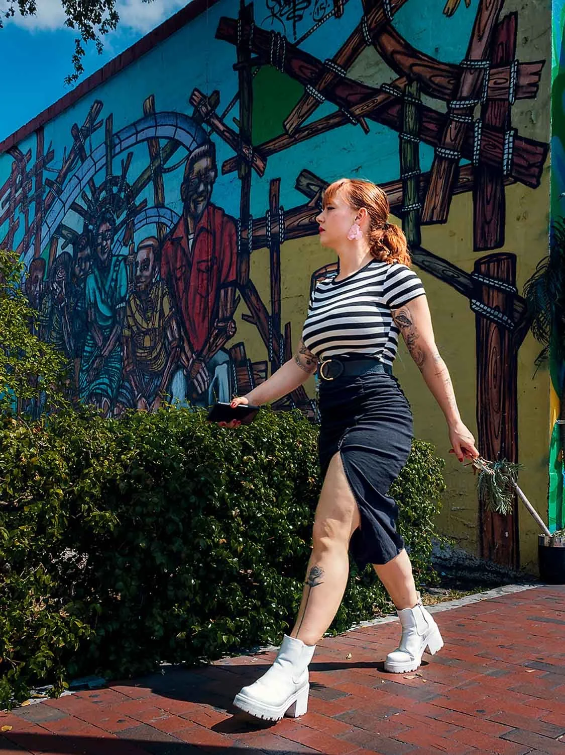 Woman walking past colorful mural in Little Havana Miami street photography scene with vibrant urban art and motion