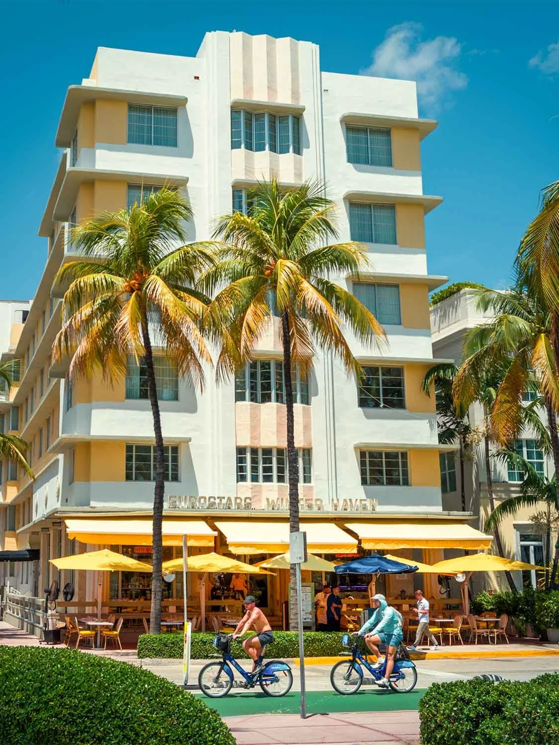 Art Deco hotel Miami Beach Ocean Drive palm trees outdoor cafe cyclists South Beach Florida travel destination