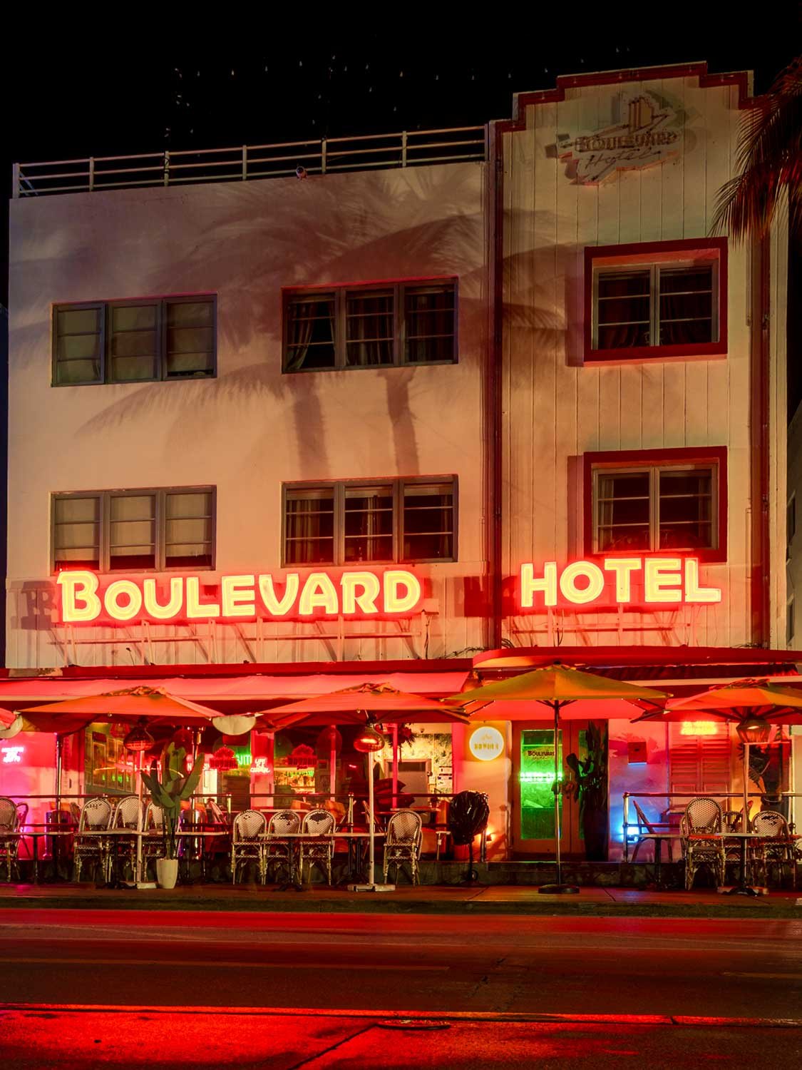 Boulevard Hotel Miami South Beach neon sign night photography Art Deco architecture outdoor seating.