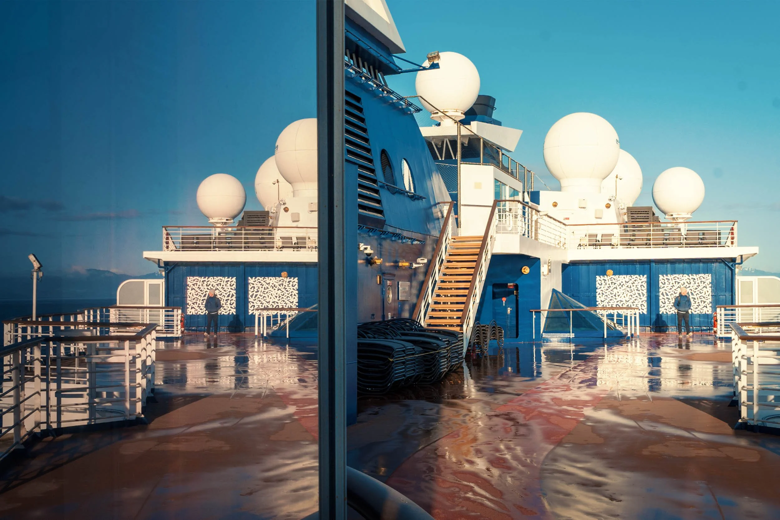 Ship's radar domes reflected in cabin window glass