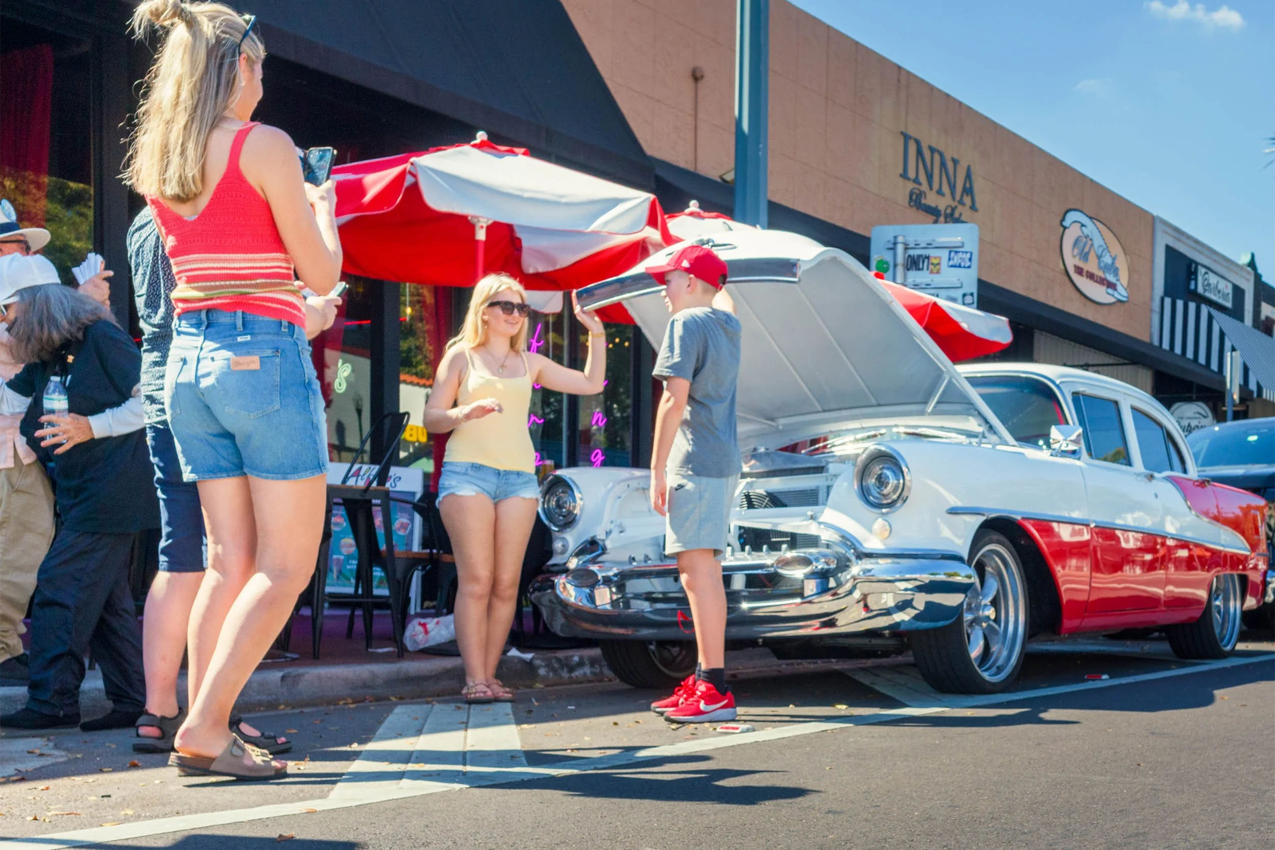 Tourists taking a photo with a classic car parked on Calle Ocho in Little Havana Miami