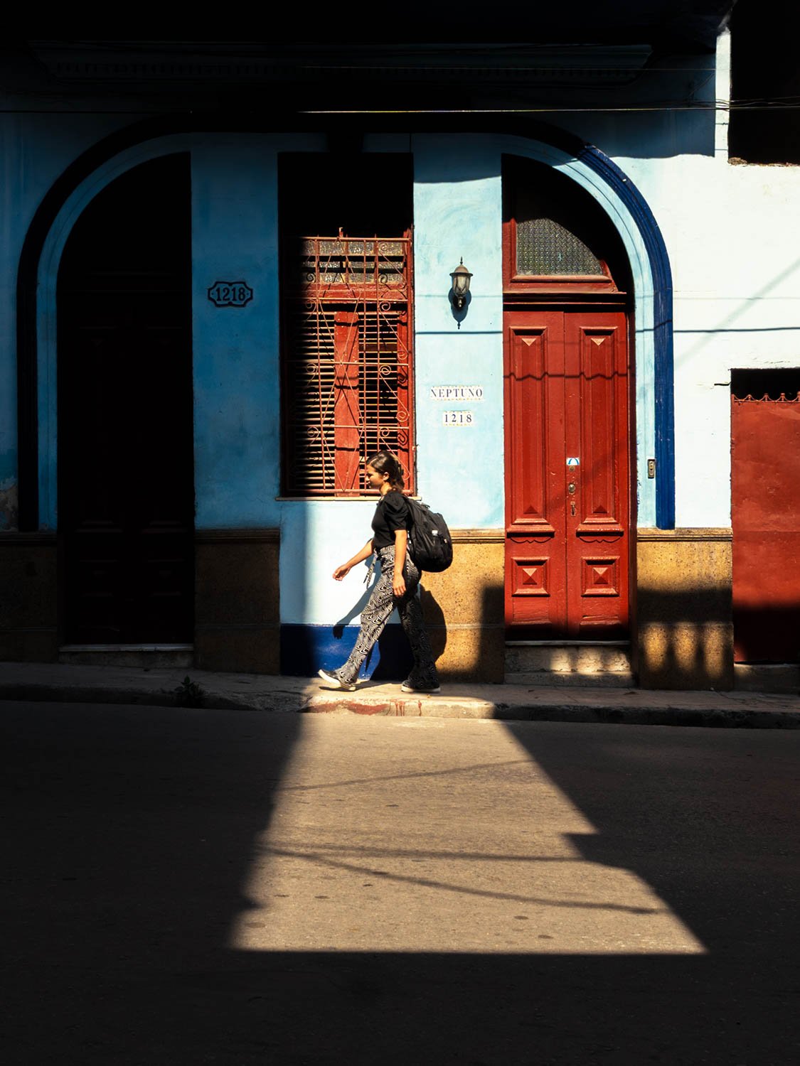 A student walking through a pocket of light on here way to the University of Havana