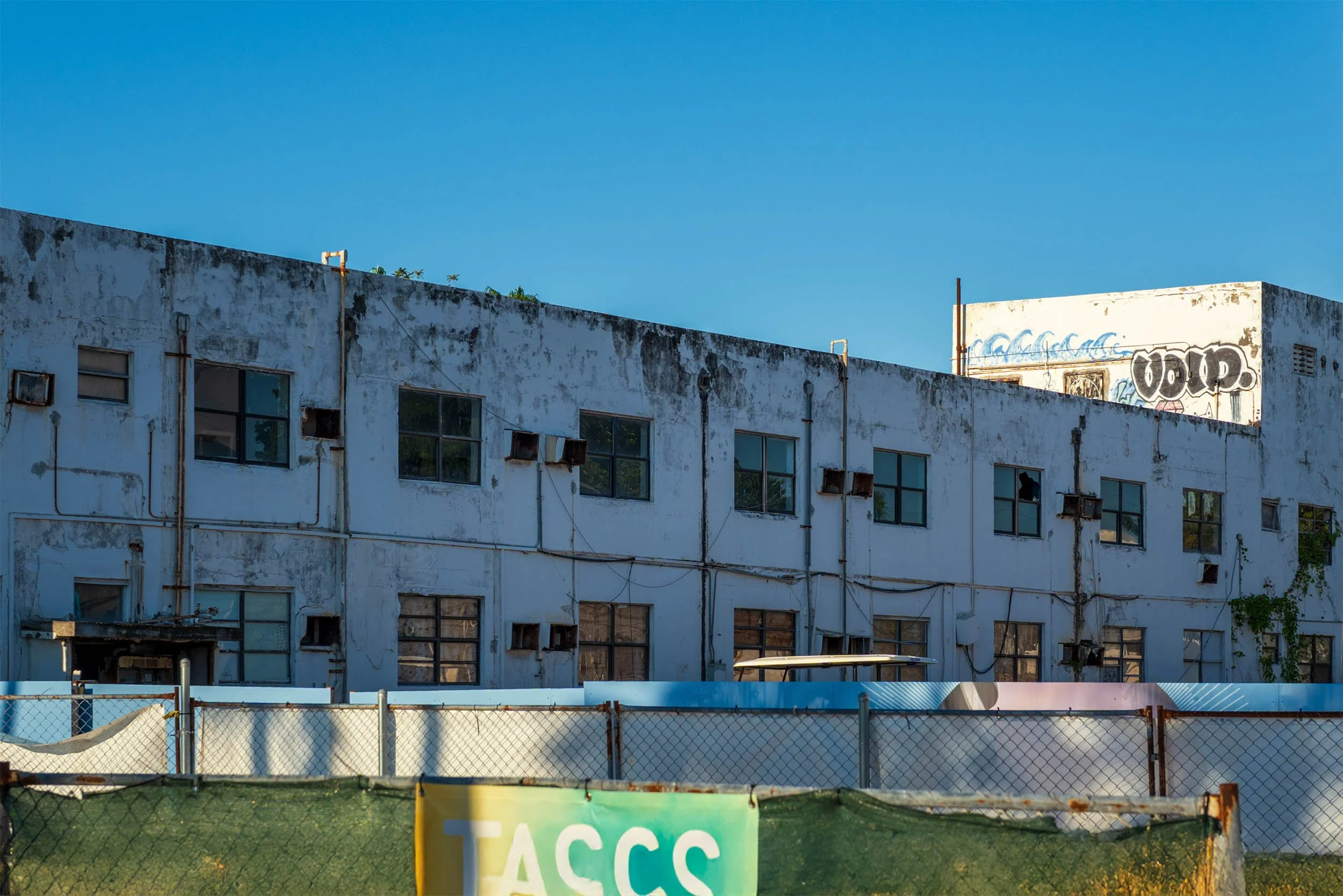 Chain-link fence and construction netting marking the empty 7420 Ocean Terrace lot where the Ocean Horizon once stood
