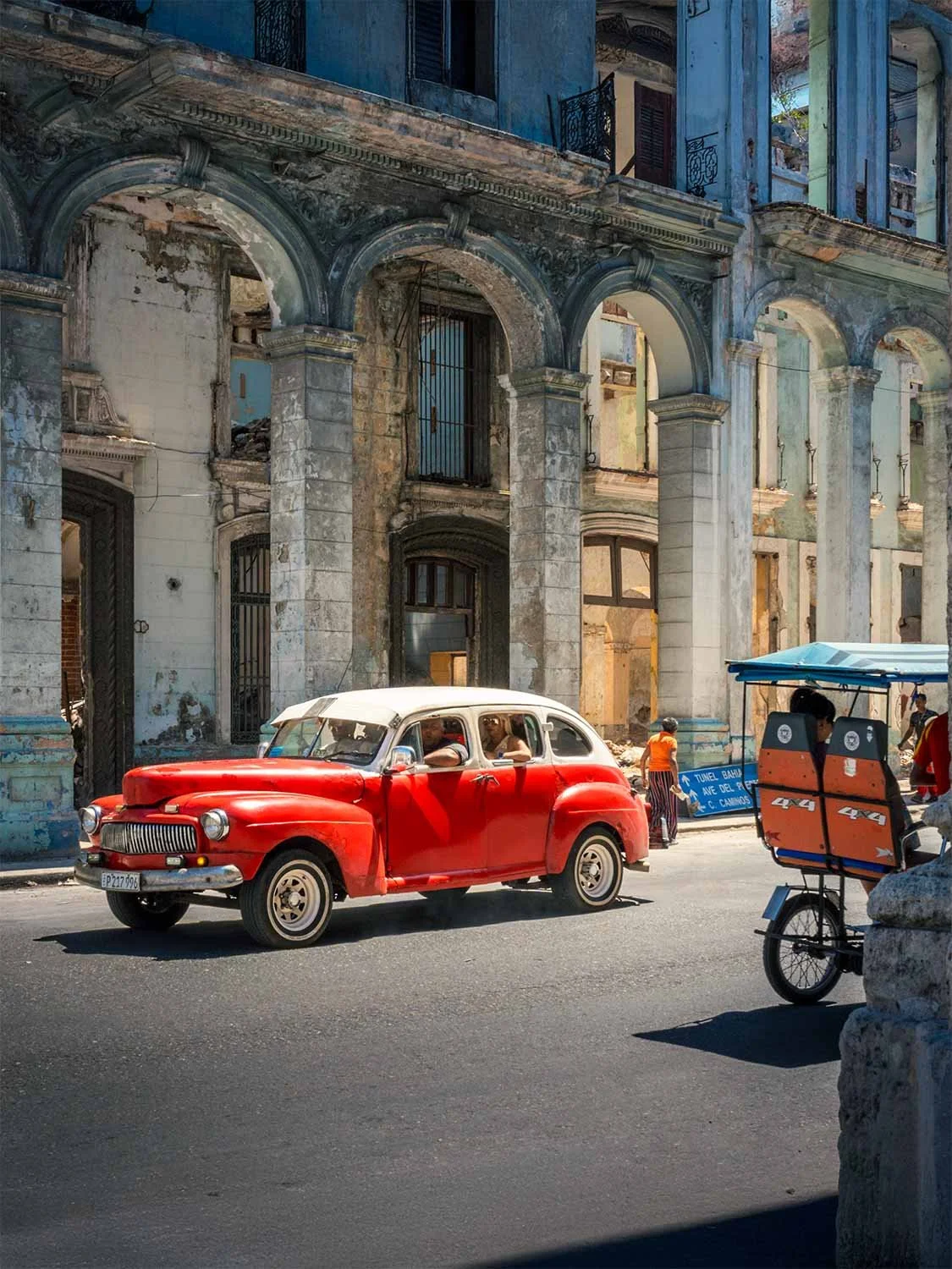 A colorful classic car driving up the street in Havana Cuba