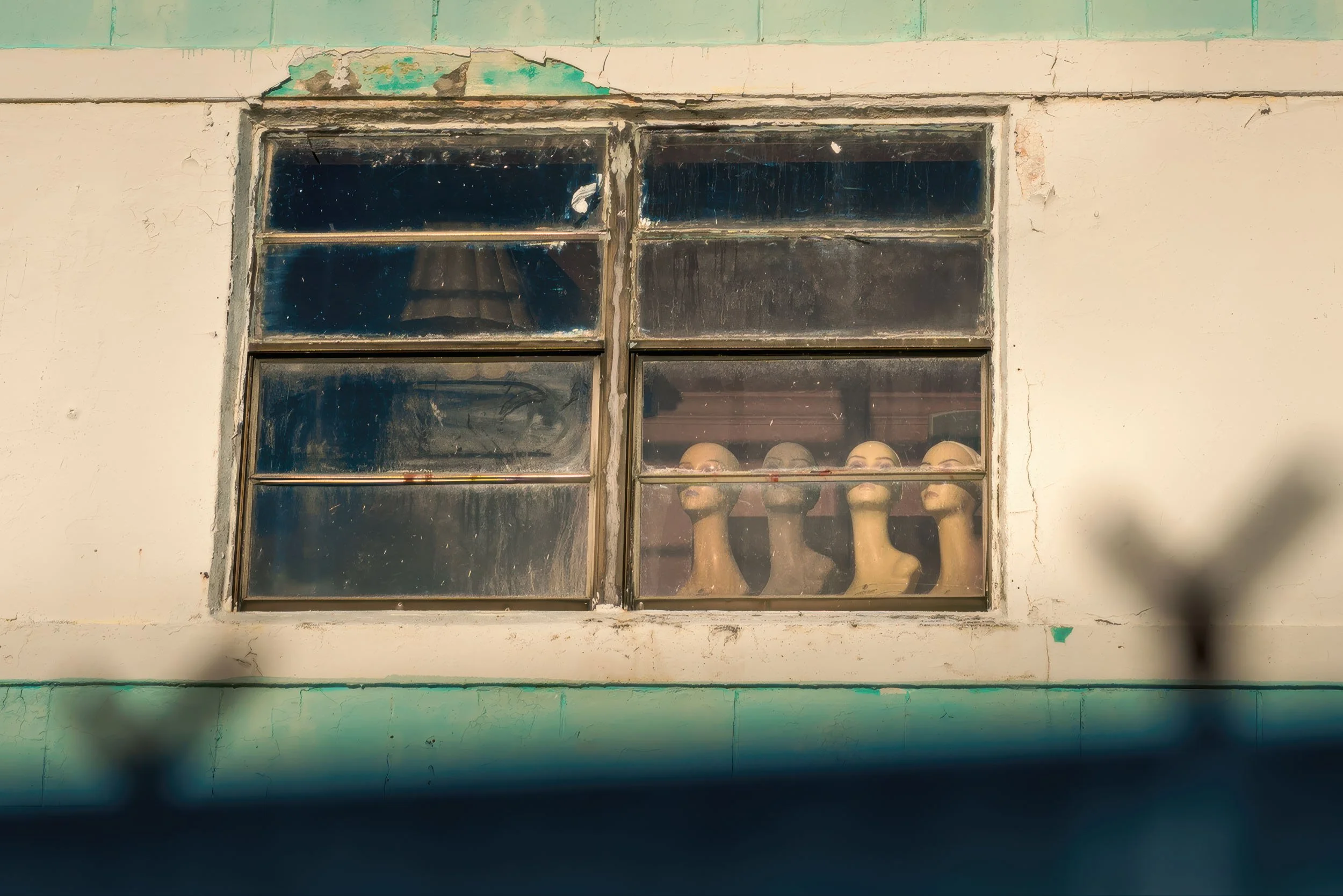Mannequin heads in a second-floor window of an abandoned hotel on Ocean Terrace, Miami
