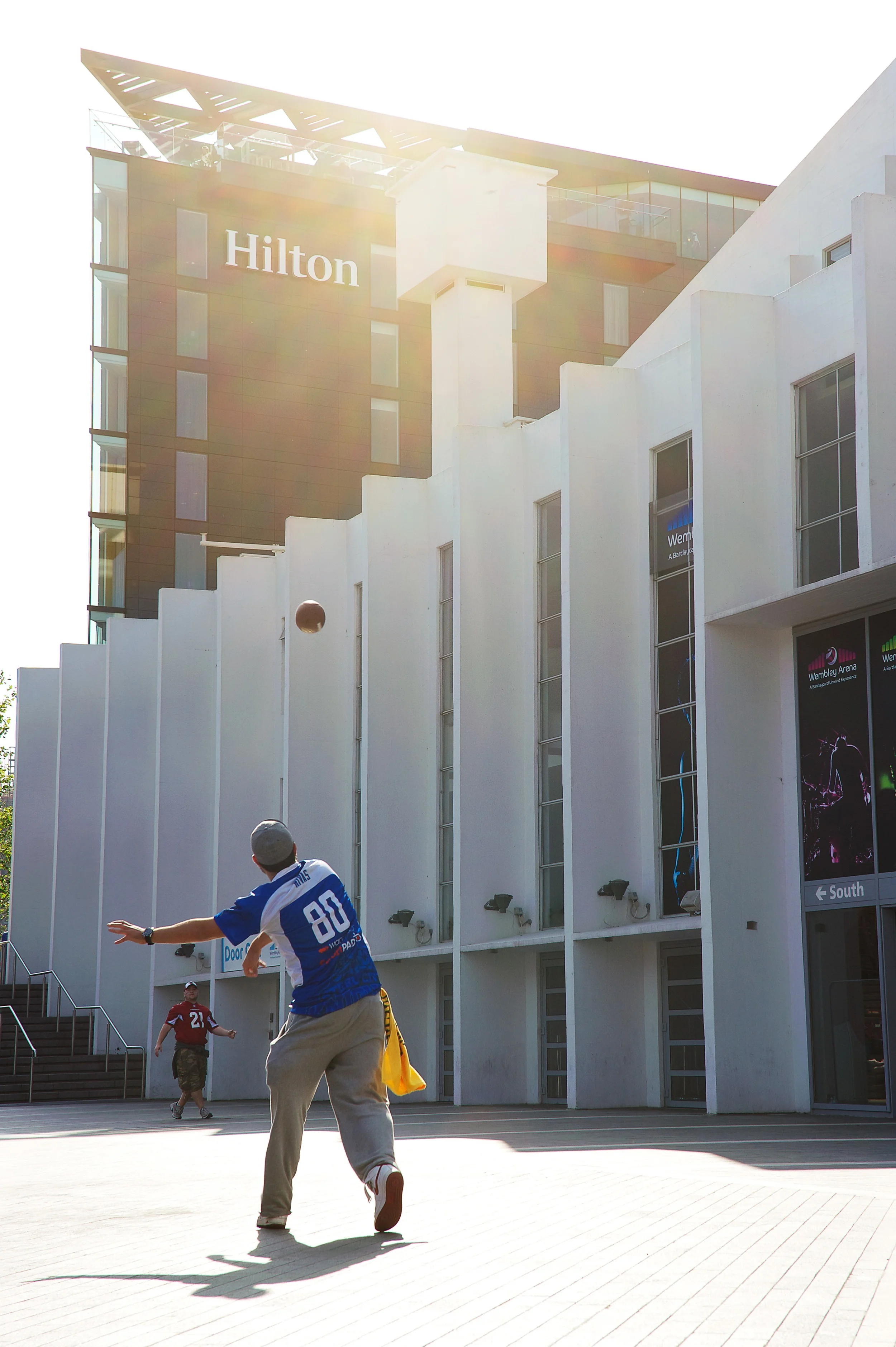American football fans play in front of The Hilton Hotel for a lifestyle shoot in Wembley during an NFL match