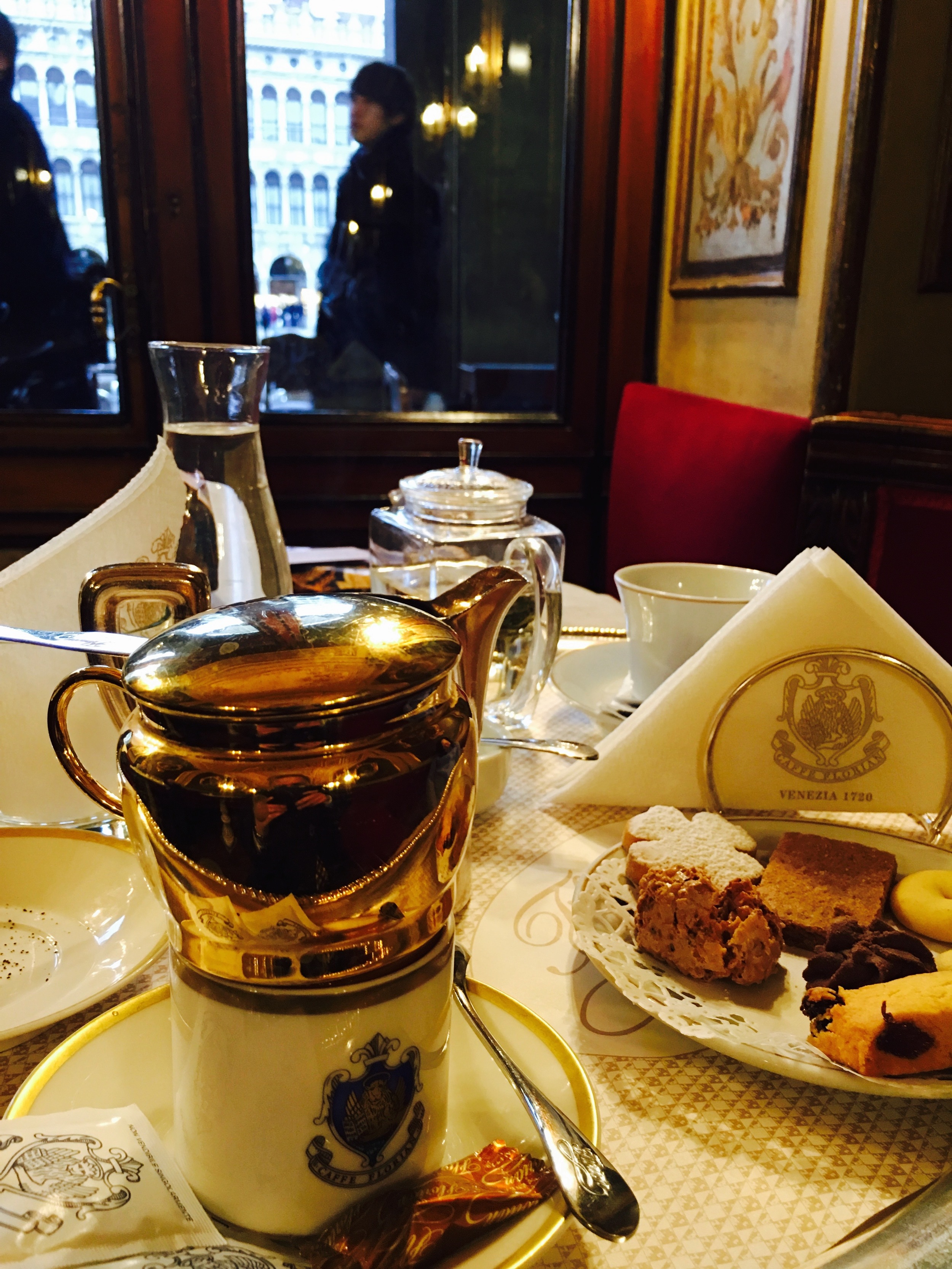  Gloriously expensive coffees and biscuits at the Cafe Florian. I humbly submit the idea that history can be made wherever you are; assuming you are capable of it. Momentous acts don’t need the angel dust of history to anoint it. That aside, the food