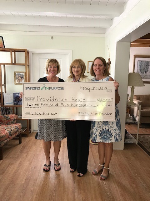 Cheryl Ollila (left) and Sandie Fleming (right) board members of Swinging With Purpose presenting executive director, Jean Takacs with their check of support.
