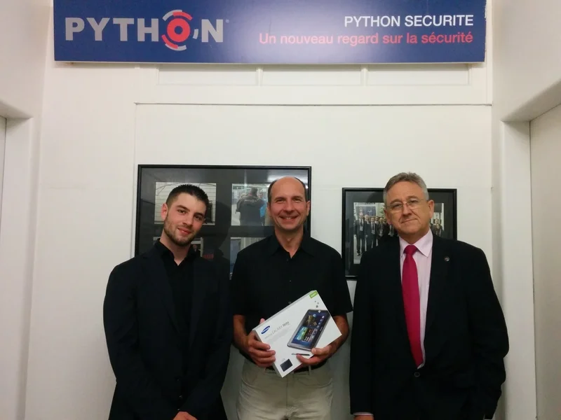 Monsieur Jean-Pierre Garnier (au centre) reçoit le SAMSUNG Galaxy Note de Monsieur Kevin Cordeiro (NODE, à gauche) et de Monsieur Christian Python (Python Sécurité Sàrl, à droite).