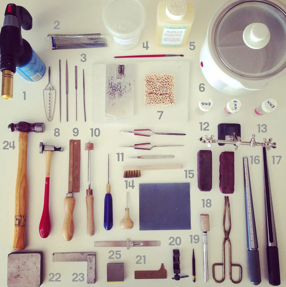 1 Blow Torch. 2 Saw Blades. 3 Small Files. 4 Pickling Solution. 5 Flux. 6 Slow Cooker. 7 Heat Proof Mat. 8 Silver Hammer. 9 Straight Saw. 10 Burnisher. 11 Needle File. 12 Easy, Medium & Hard Solder. 13 Third Arm. 14 Pusher. 15 Tripolloi & Rouge. 16 Ring Sizer. 17 Mandrel. 18 Brass Tongs. 19 Centre Punch. 20 Small Vice. 21 Measuring Tools. 22 Steel Block. 23 Set Square. 24 General Purpose Hammer.