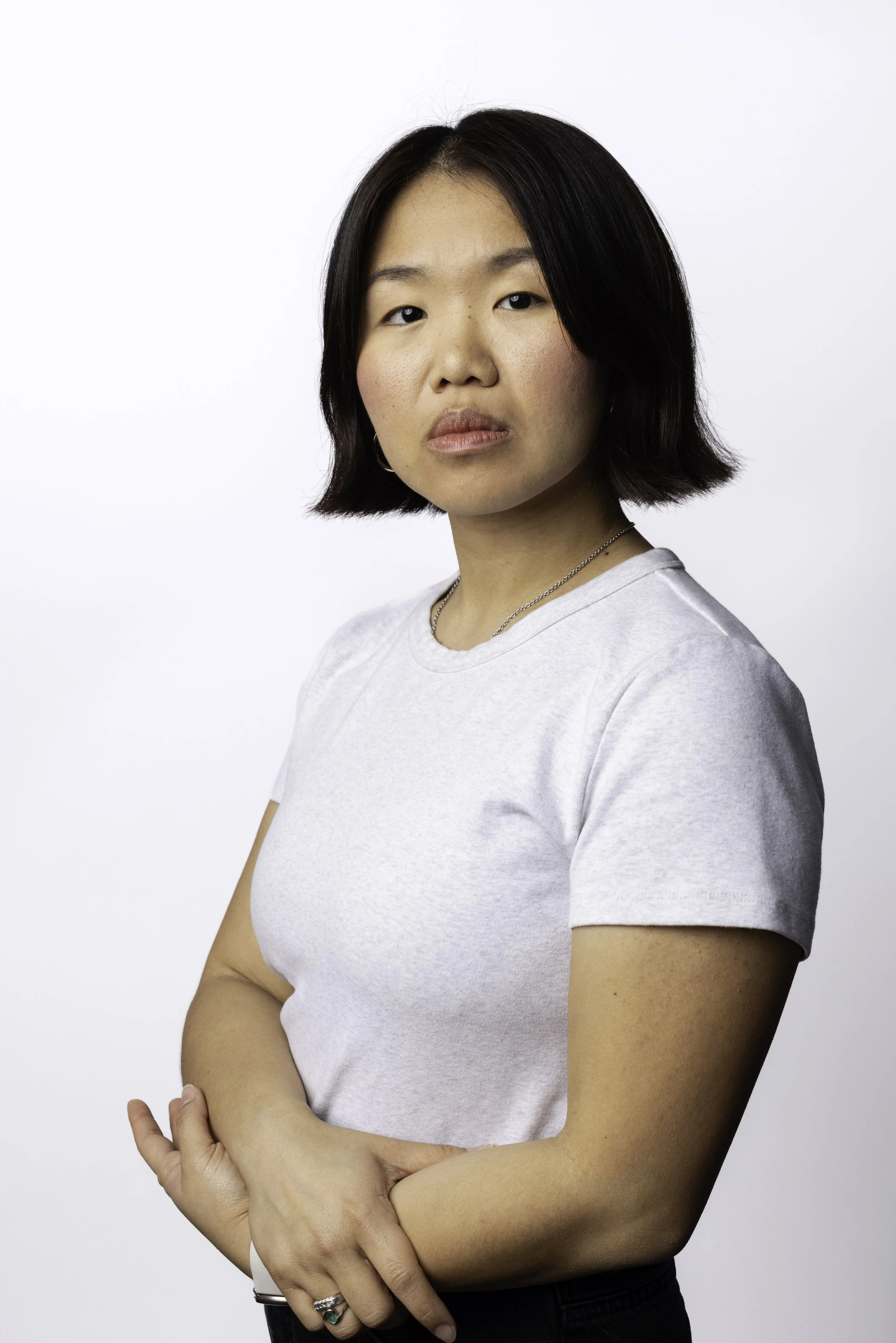 Headshot of Pu Ying Huang in a light grey t shirt and black pants. Her arms are gently folded over down by her waist. She offers a neutral expression.