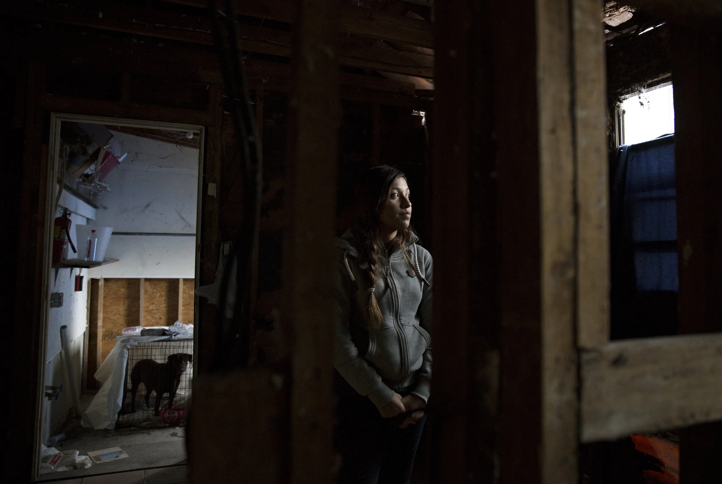 Anita Miranda, 24, stands in the kitchen where the roof first collapsed from Hurricane Harvey's rains. Unable to secure housing after Hurricane Harvey, the family returned to their storm-damaged home where rooms are gutted, utilities don't work and uncertainty about repairs continue to linger.