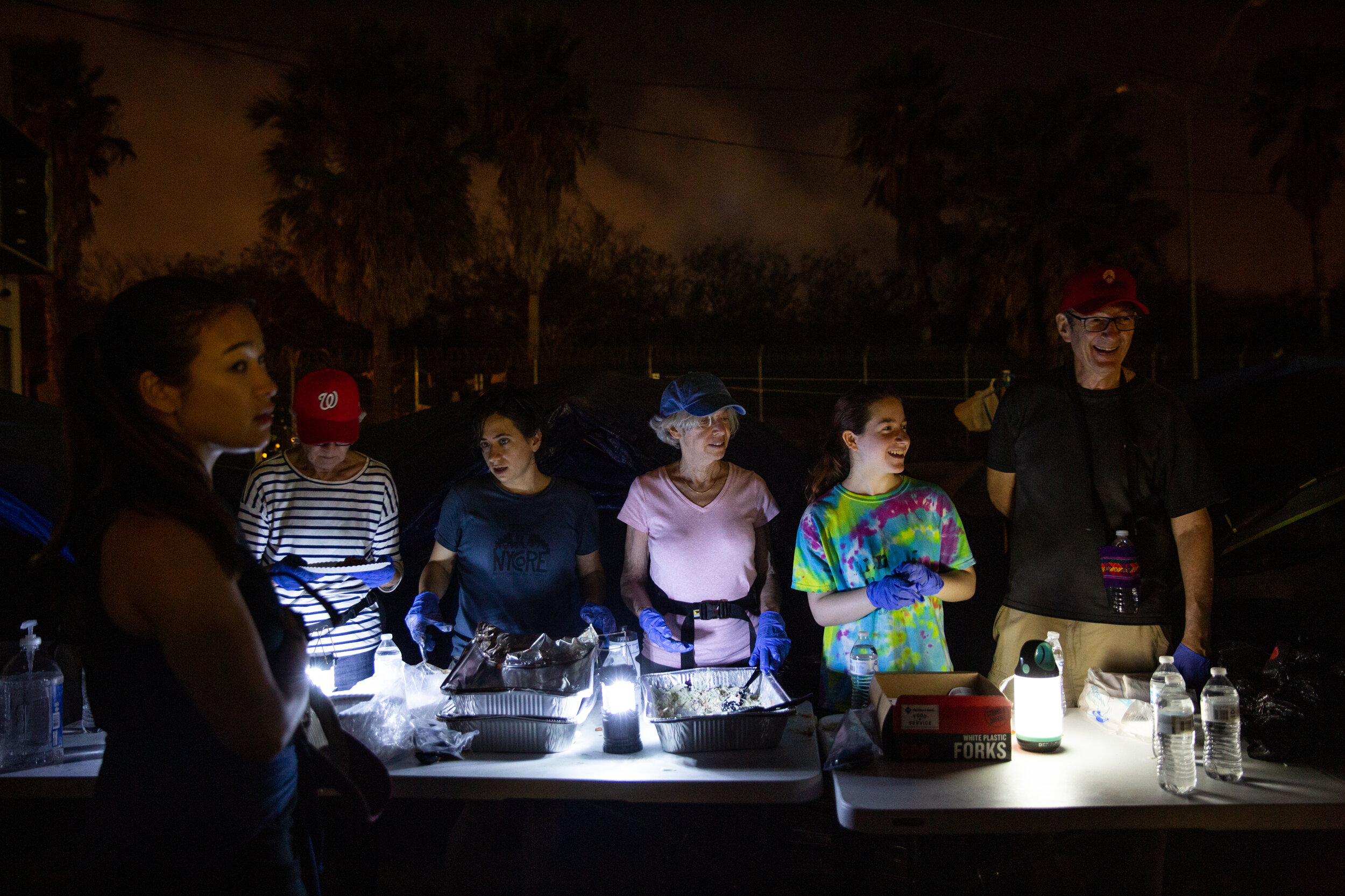  Volunteers from a synagogue in Washington D.C. serve homemade dinner to migrants outside the Matamoros encampment.  