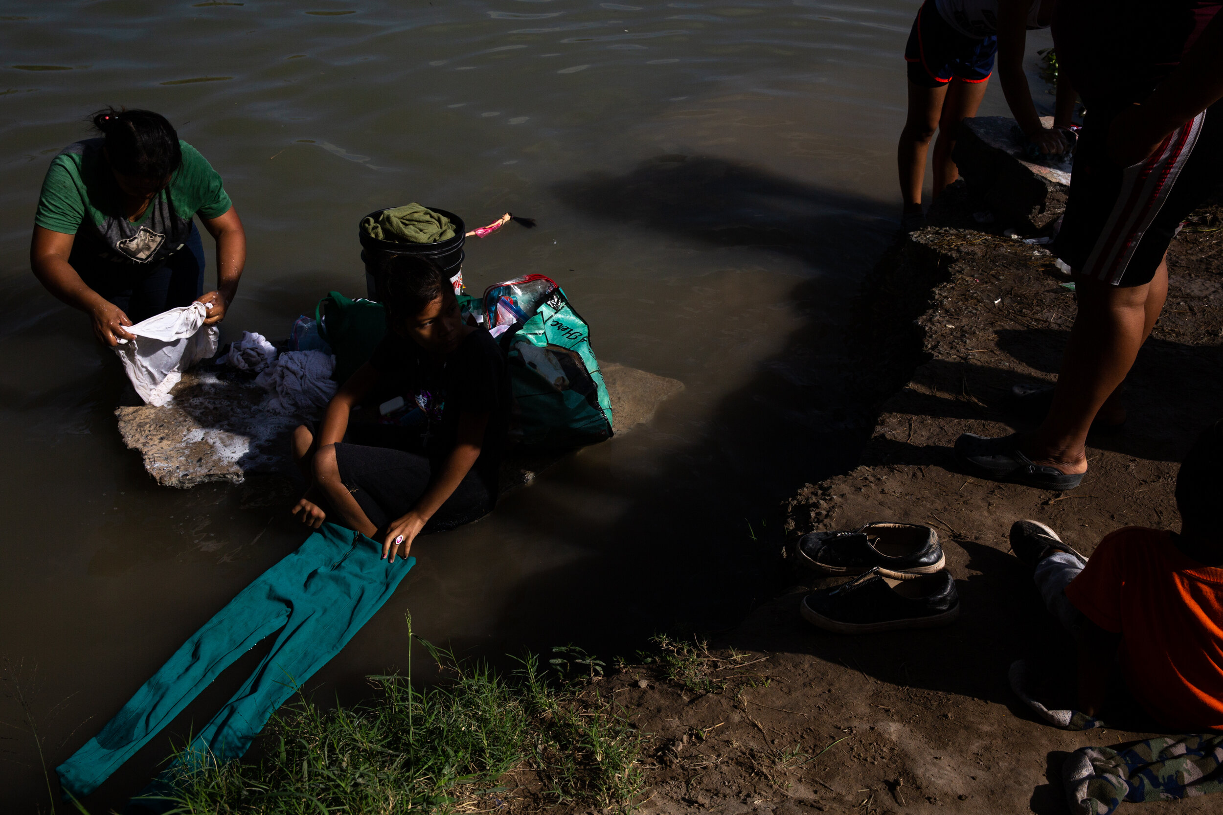  Migrant women from the Matamoros encampment wait in line to wash clothes by the banks of the Rio Grande on Jan. 14, 2020.  