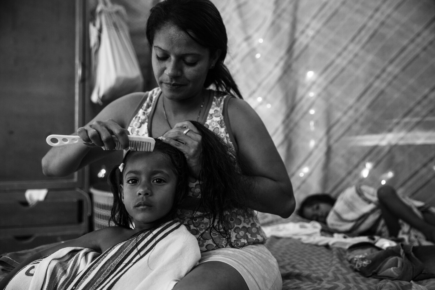  Leibys Garcia combs her daughter's hair in the bedroom that they share as a family. The Garcia family left Venezuela in search of stable work and housing over a year ago, but in a country overwhelmed by the Venezuelan migration, Leibys ended up here