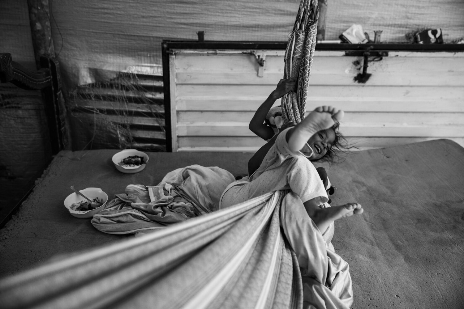  Twin sisters Leismar Sanchez and Lismar Sanchez play on a hammock during lunch time.  