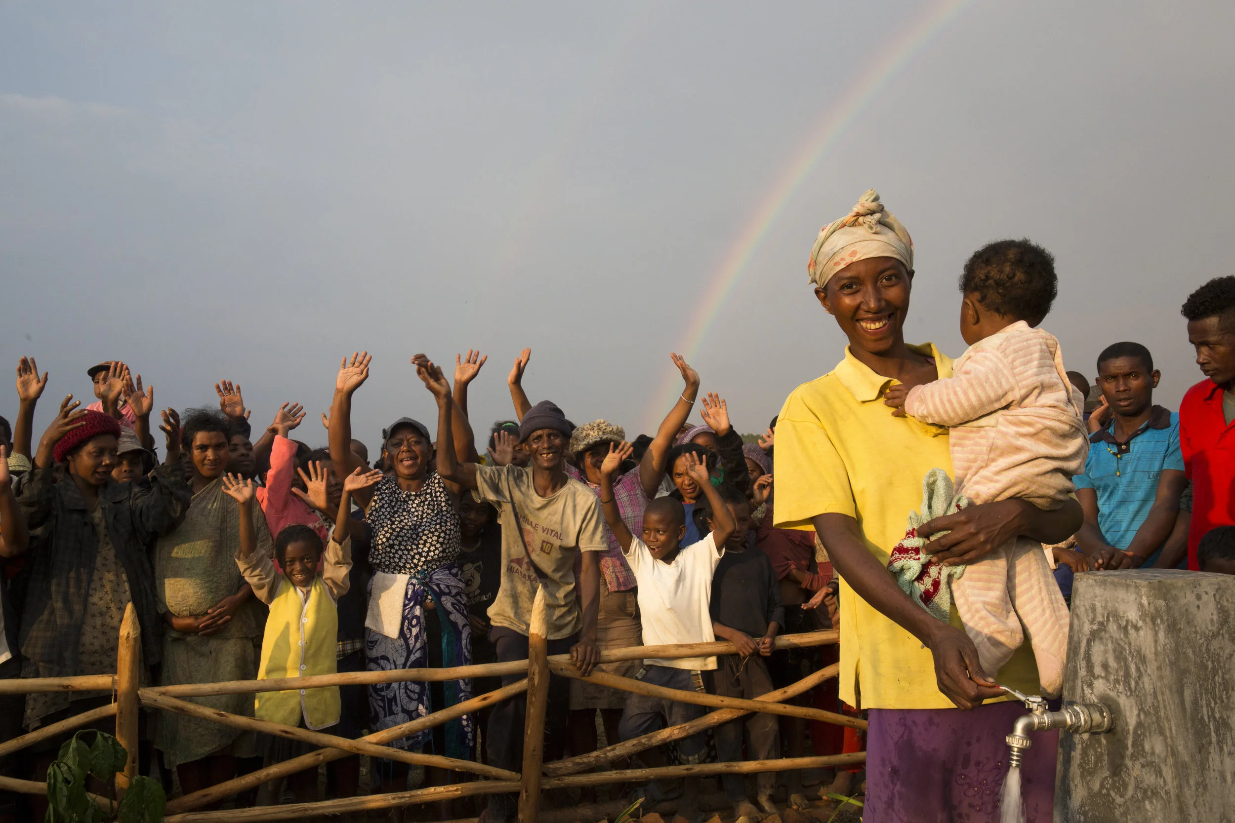 A happy group photo of villagers in Tsarafangitra with Raoly, 28, and her baby girl, Natasha, nine months old, fetching water for the first time in her village in Tsarafangitra Village. (Photo: WaterAid / Ernest Randriarmalala)