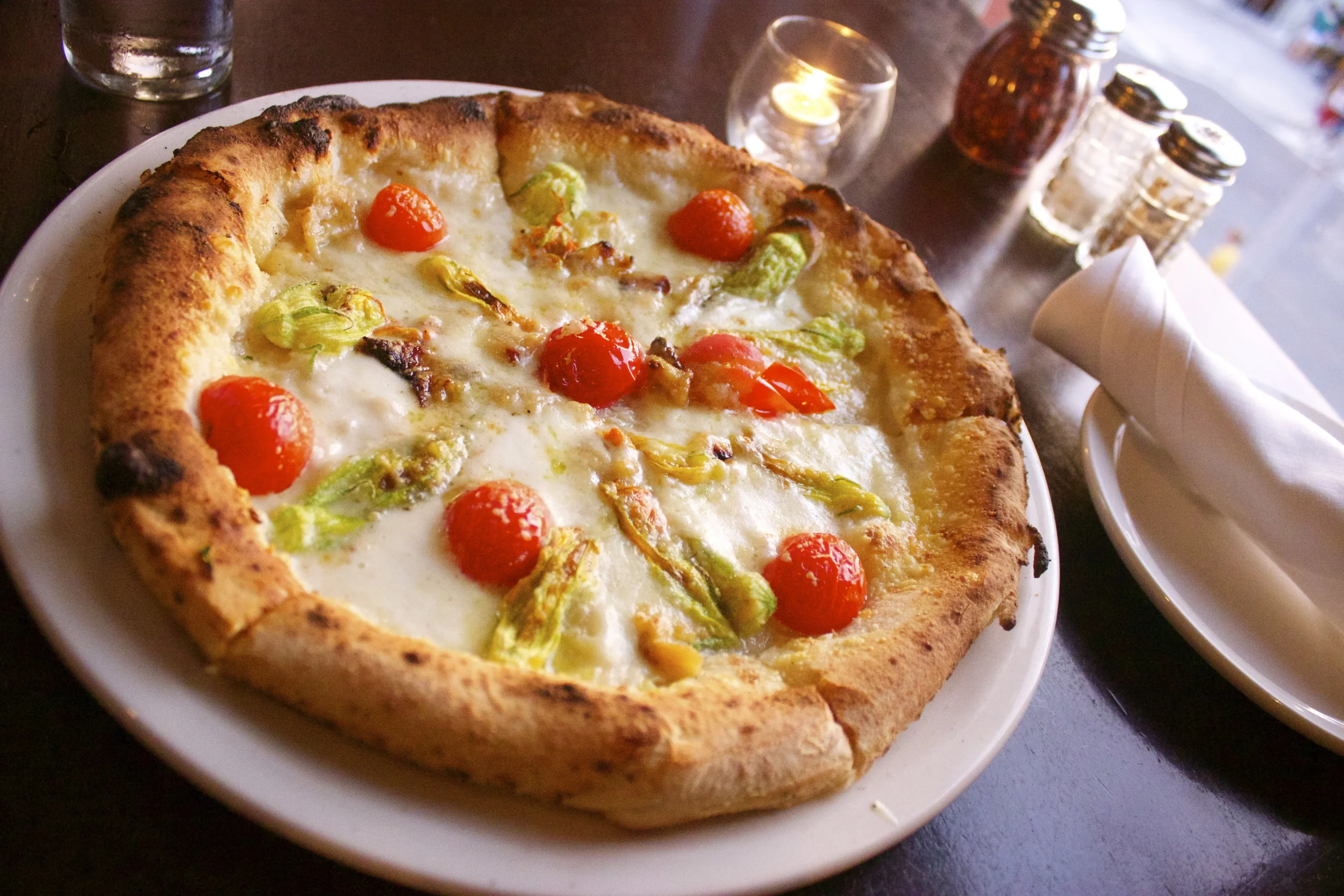 RedRocks Firebrick Pizza : A white pizza with an olive oil base, burrata, garlic, cherry tomatoes, and squash blossoms.
