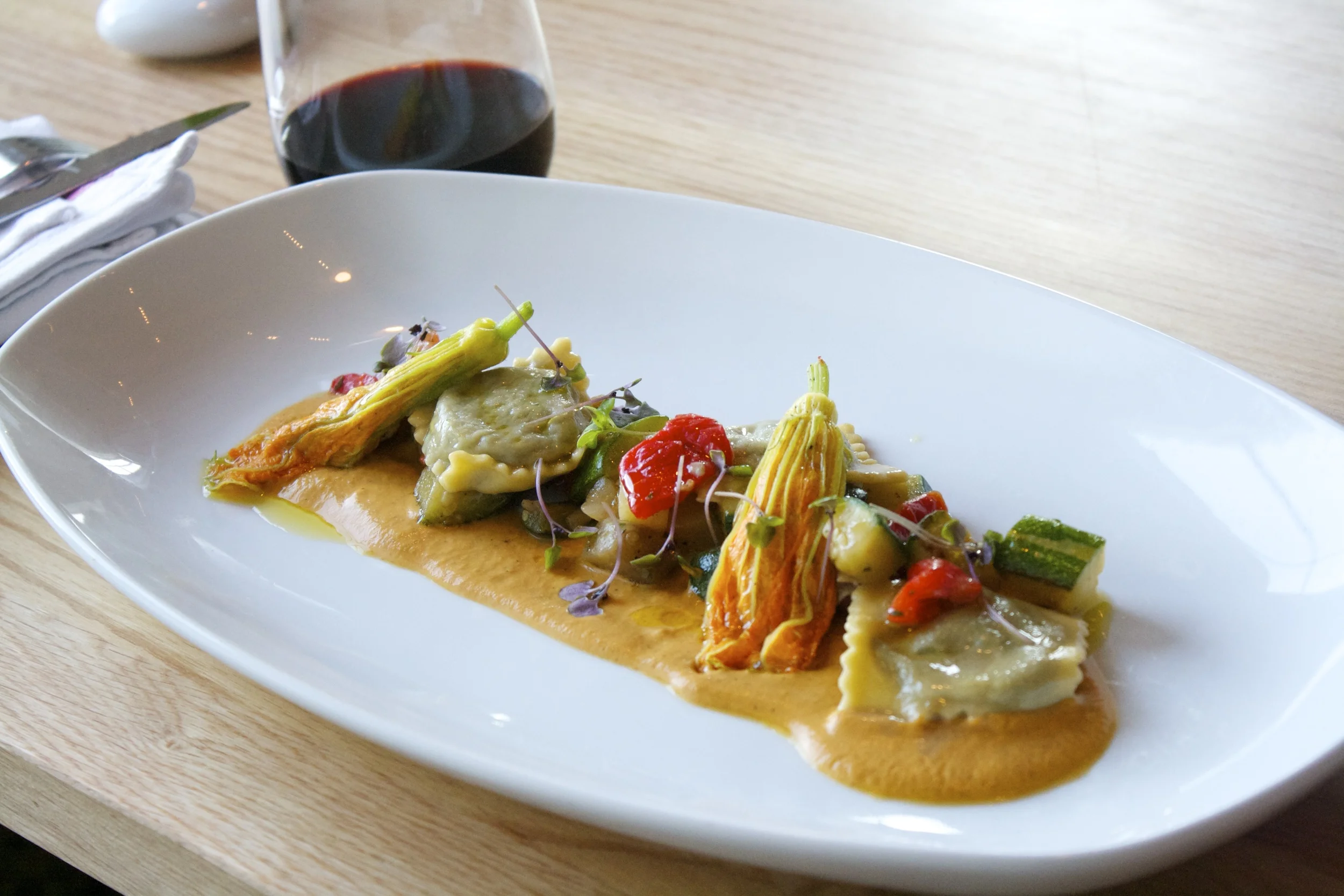 Table: Escargot ravioli with a ratatouille of zuchinni, tomato, red pepper, eggplant, purple basil and ricotta-stuffed squash blossoms with saffron.