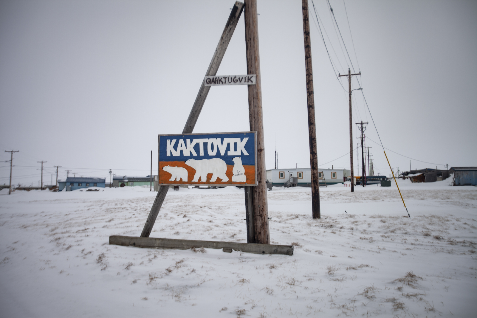 Sign at the edge of town which includes an alternate spelling: Qaaktugvik