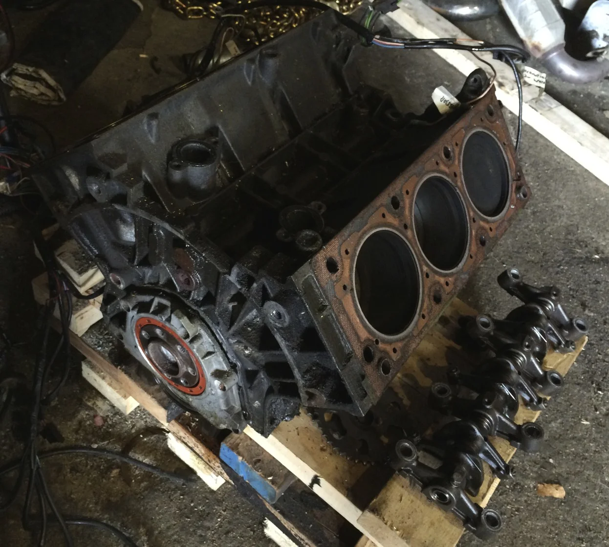 Block with the cylinder heads removed. A set of rocker arms is sitting on the pallet to the right of the block.