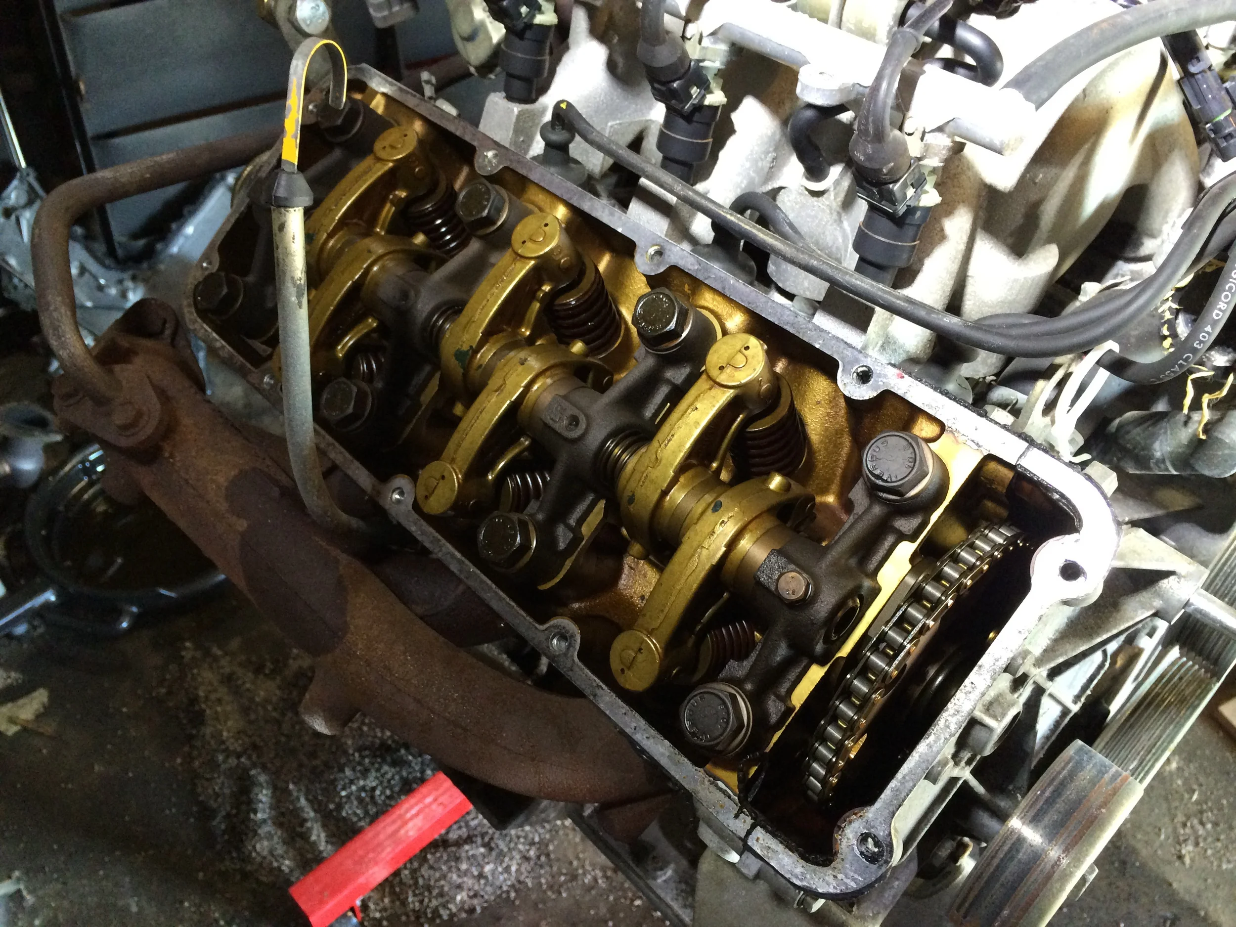 The valve train is revealed once the cylinder heads are removed. The rocker arms have a golden color, while the 2.8L engine has black rocker arms.