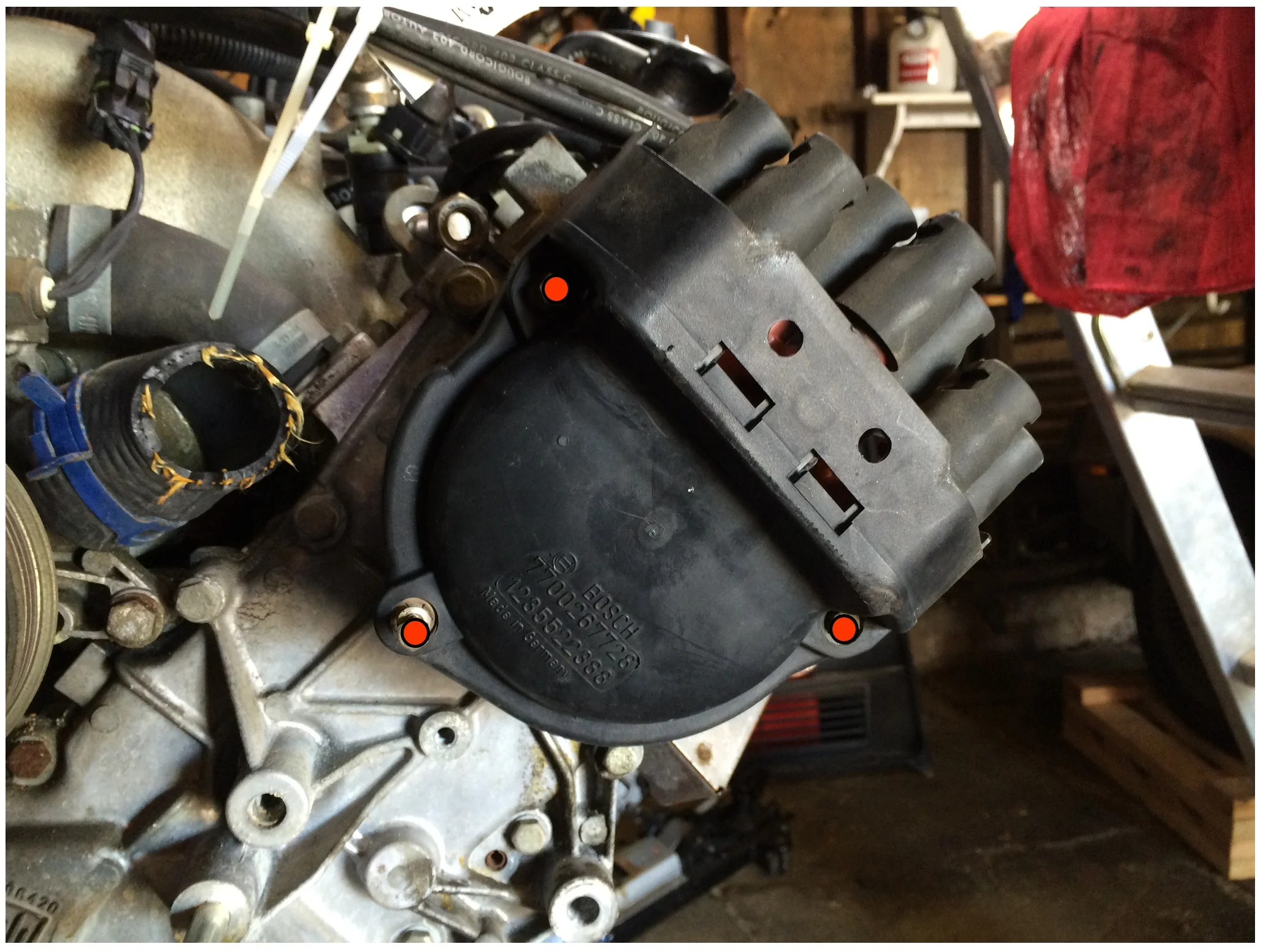 The three red dots mark the nuts for the distributor cap. These can be removed with a 7mm or 5/6" socket.