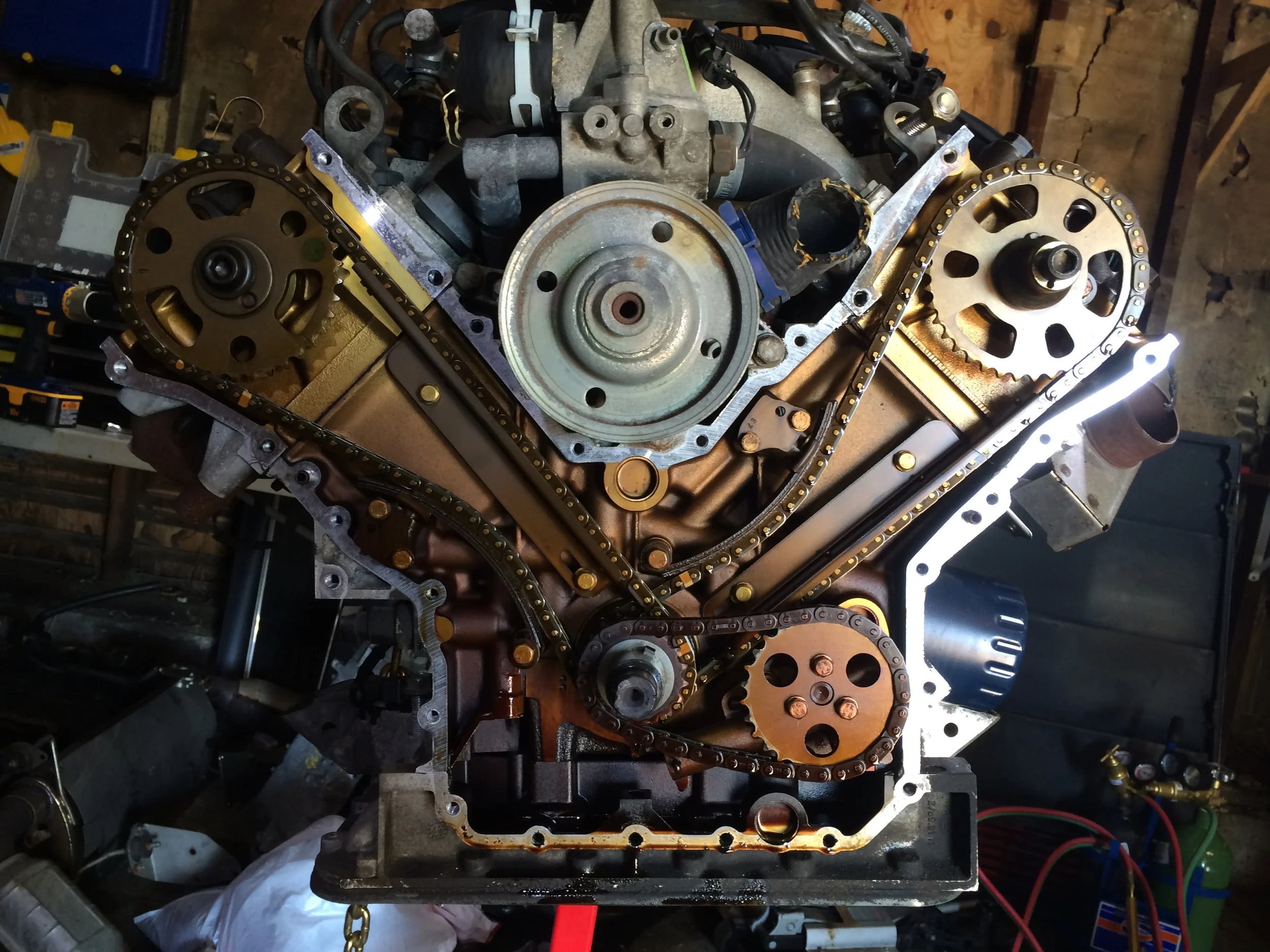 The timing cover removed, revealing the golden internals of the 3.0L engine.