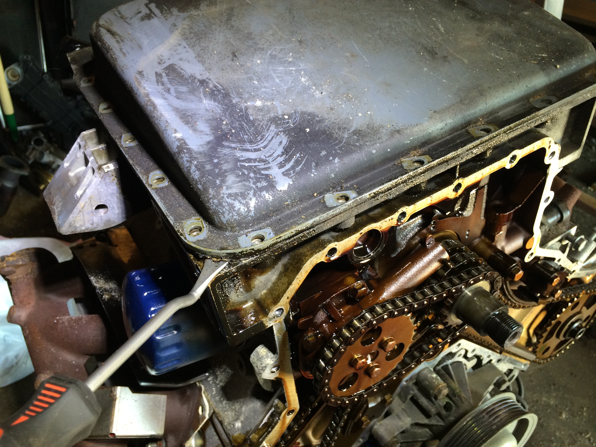 Lightly prying off the oil pan from the corner.