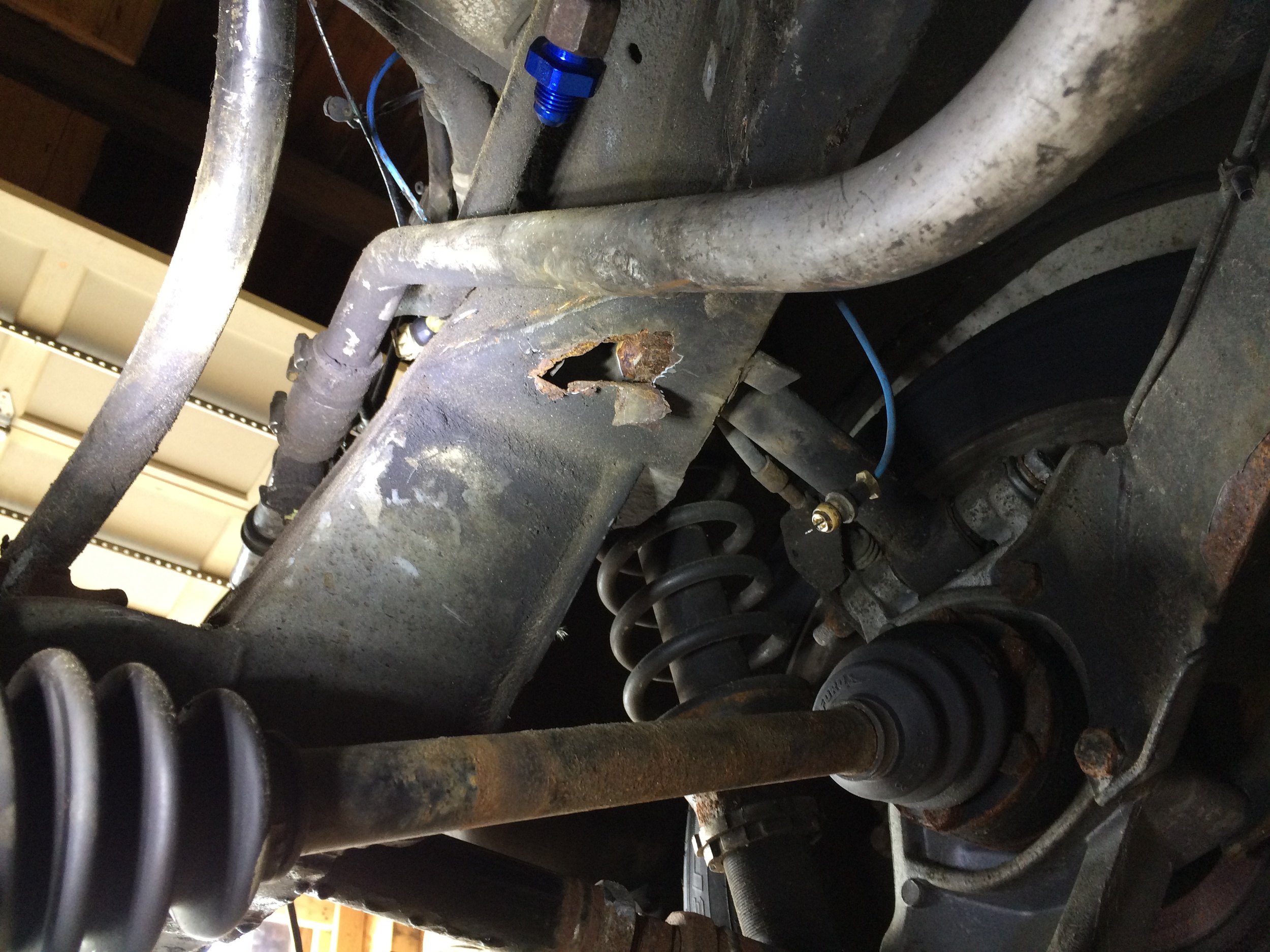 Driver's side hole in the same location under the lower link arm.