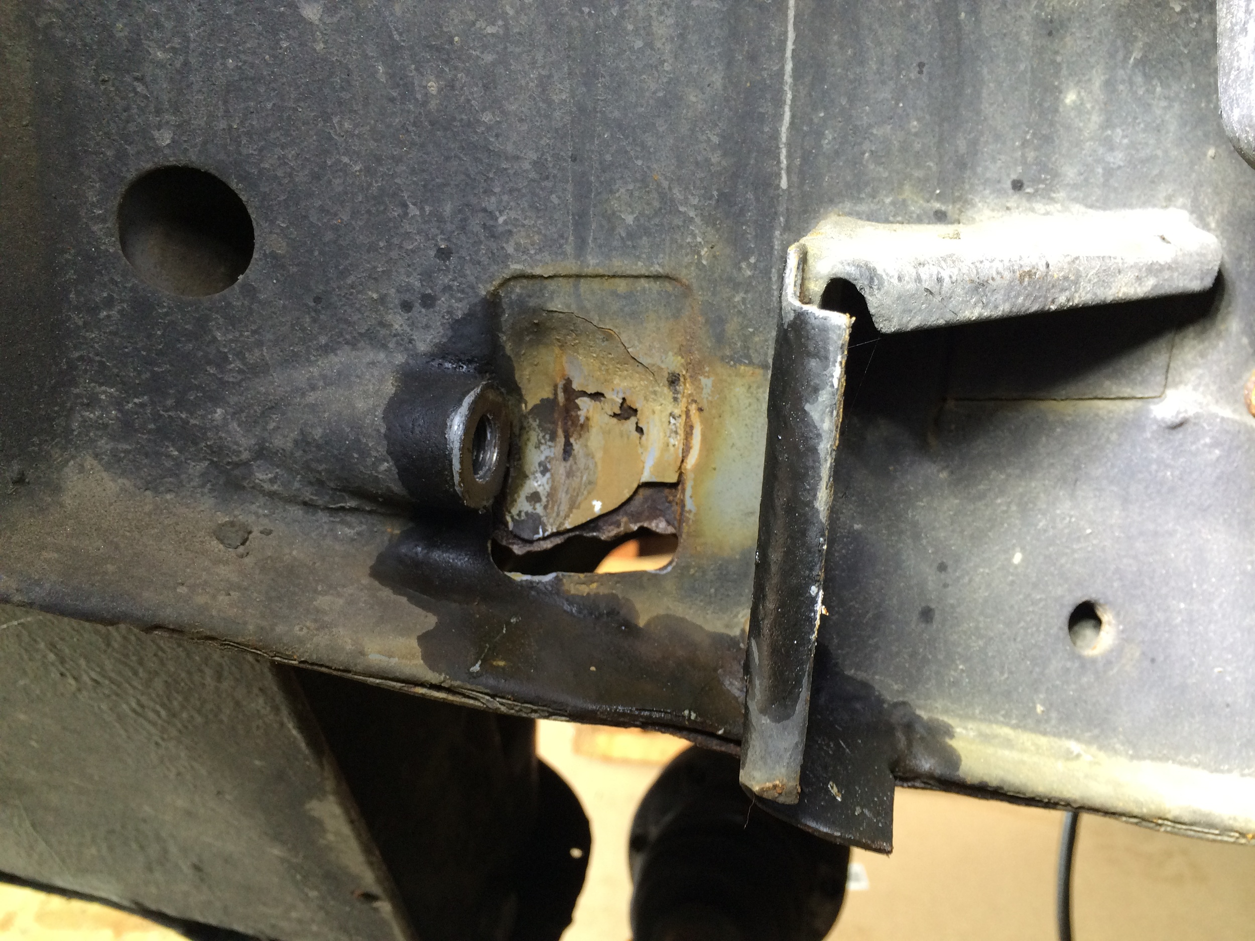 With the link arm removed, the hole is more clearly visible, as is the loose epoxy on the plate.
