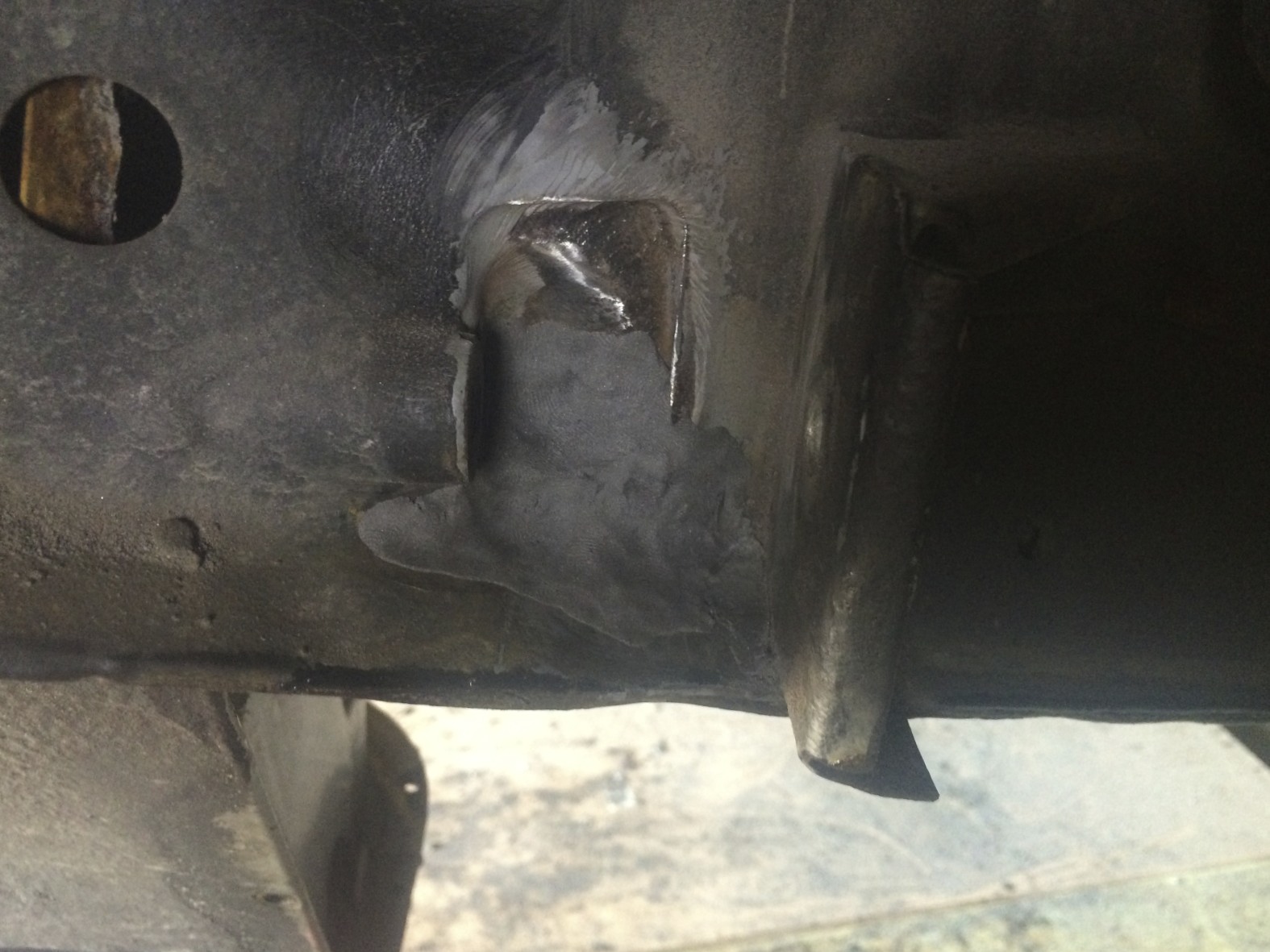 The hole soon after patching it with the putty. Care was teen to blend the edges and to make sure that the shape was similar to the original plate so that the link arm would fit properly, as well as pushing it inside the frame to make sure it has as much grip as possible. 