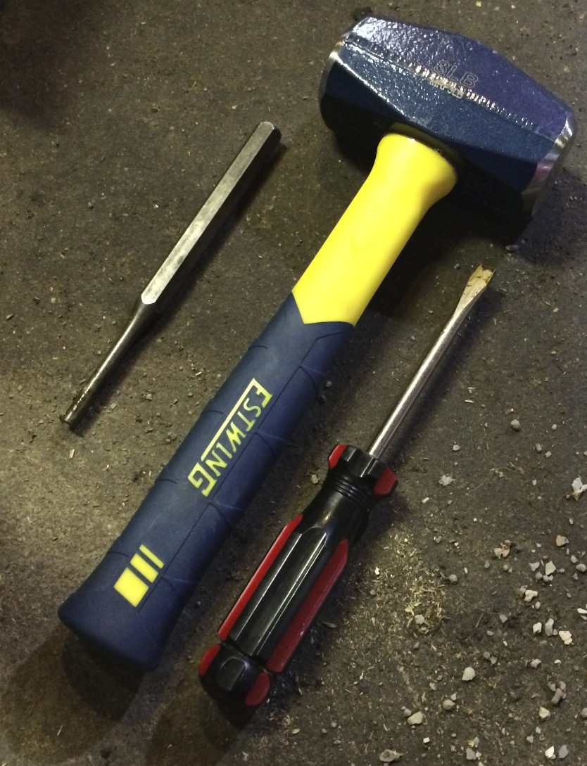 Tools used to remove the plug: a four pound hammer, a punch and a flathead screwdriver.