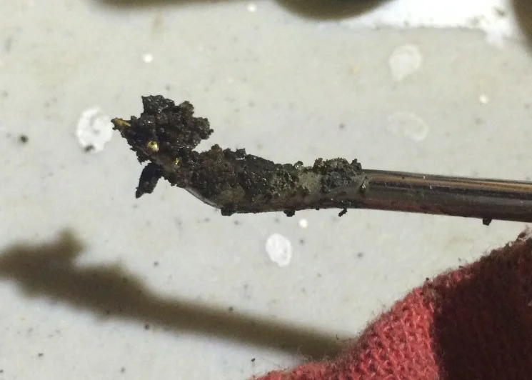 Some of the dried oil removed with some picks from the hole.