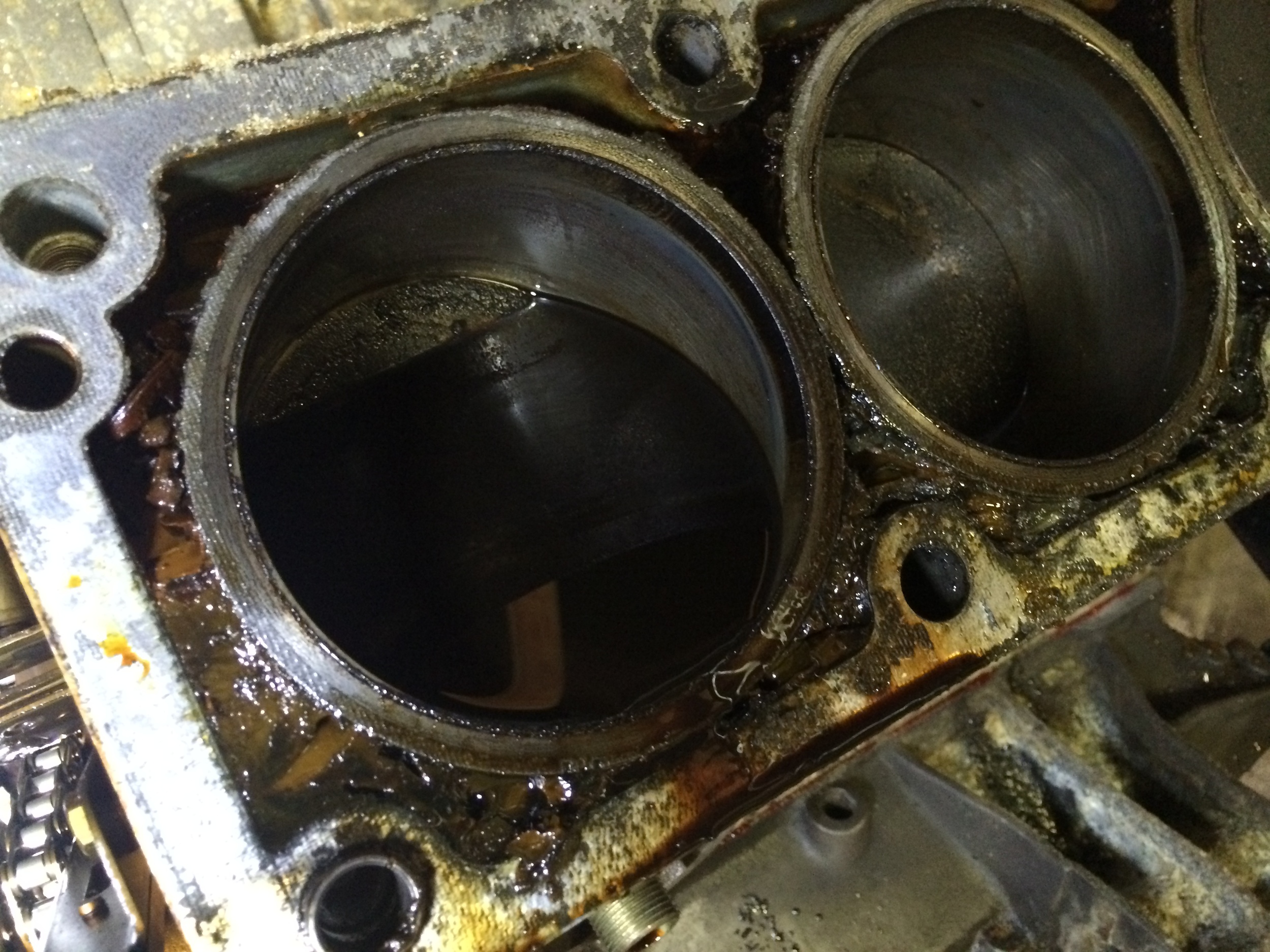 Oil collected in one of the cylinders, and oil/coolant mud filling the coolant jacket around them.