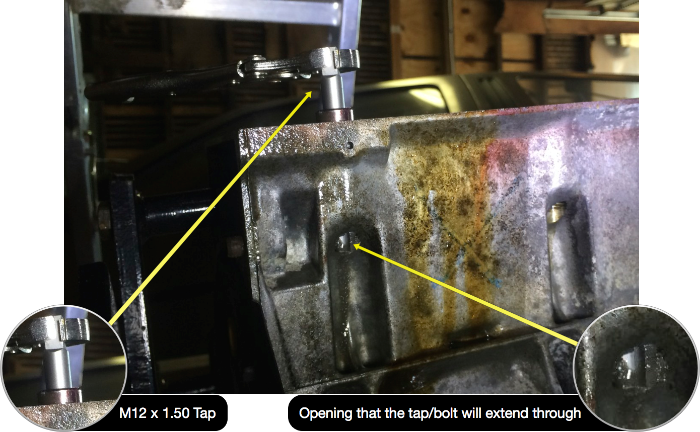 The M12 x 1.50 tap being used to re-tap and clean the head bolt threads. The tap/bolt extends through the open-ended hole.