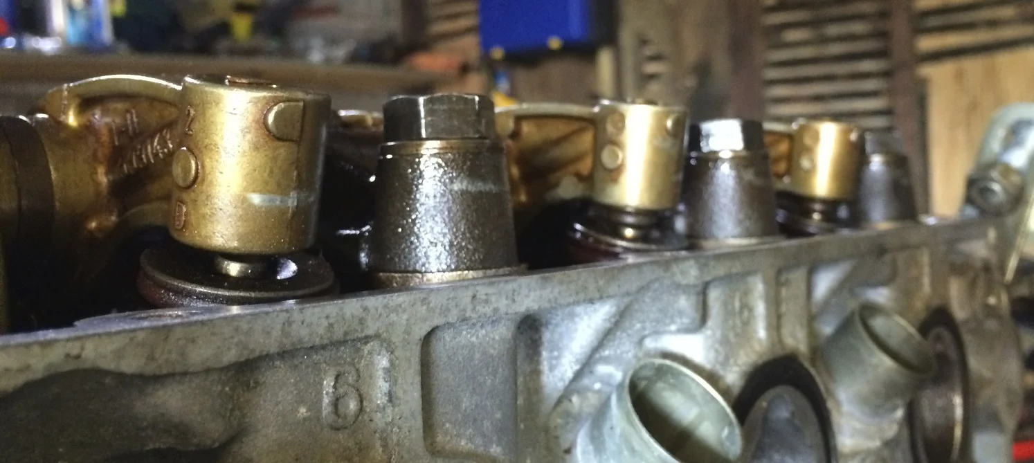 The gap between the leftmost finger and the valve stem shows where I didn't notice one of the tappets slip out. You can see the tappet sticking out from under the other two fingers.